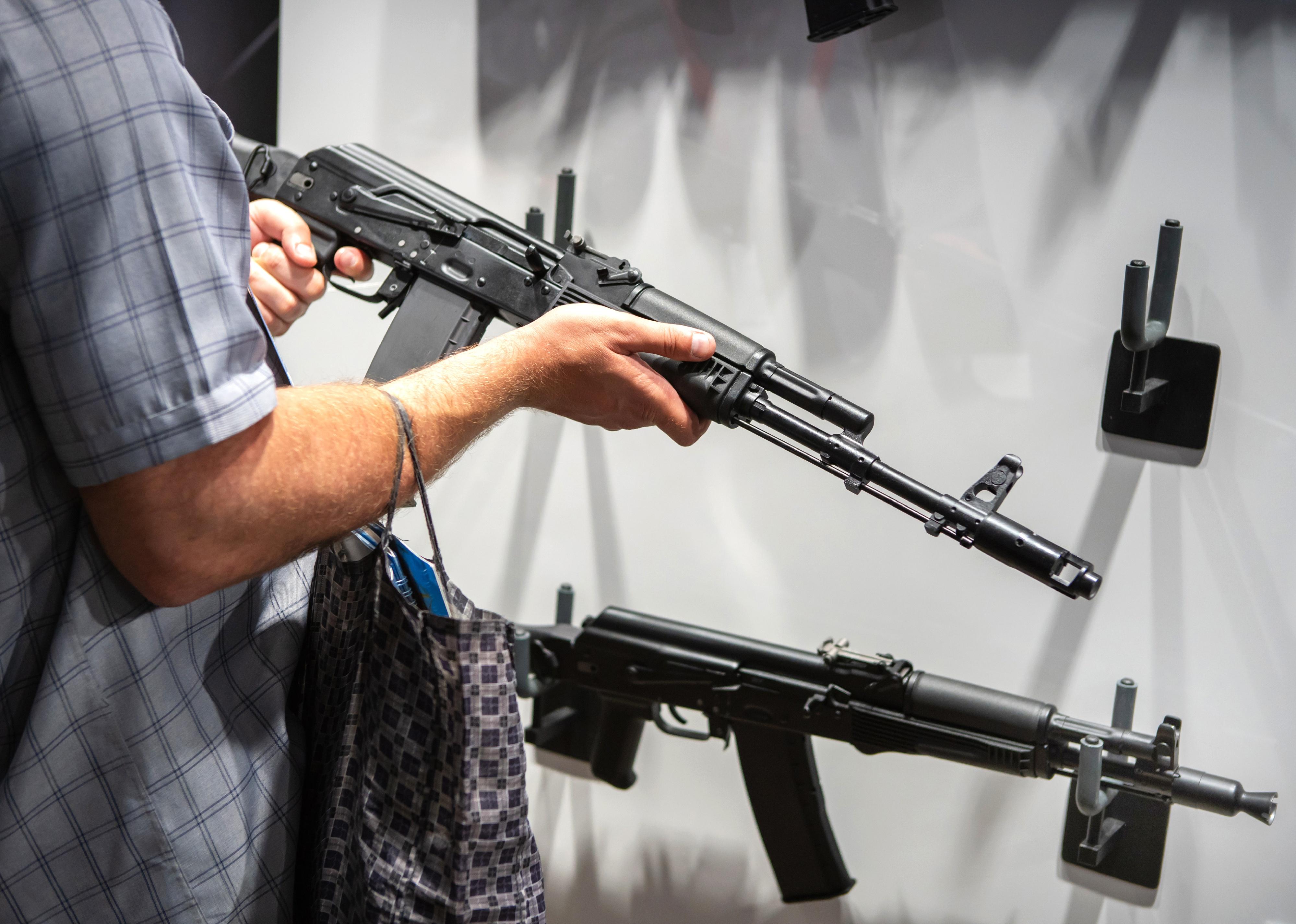 A person examines samples of firearms.