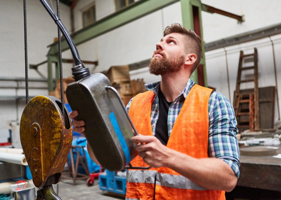 Worker at the control panel of a coordinate drilling machine