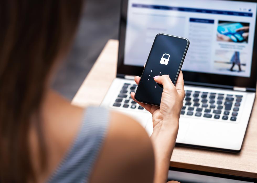 Woman holding smartphone with locked screen.