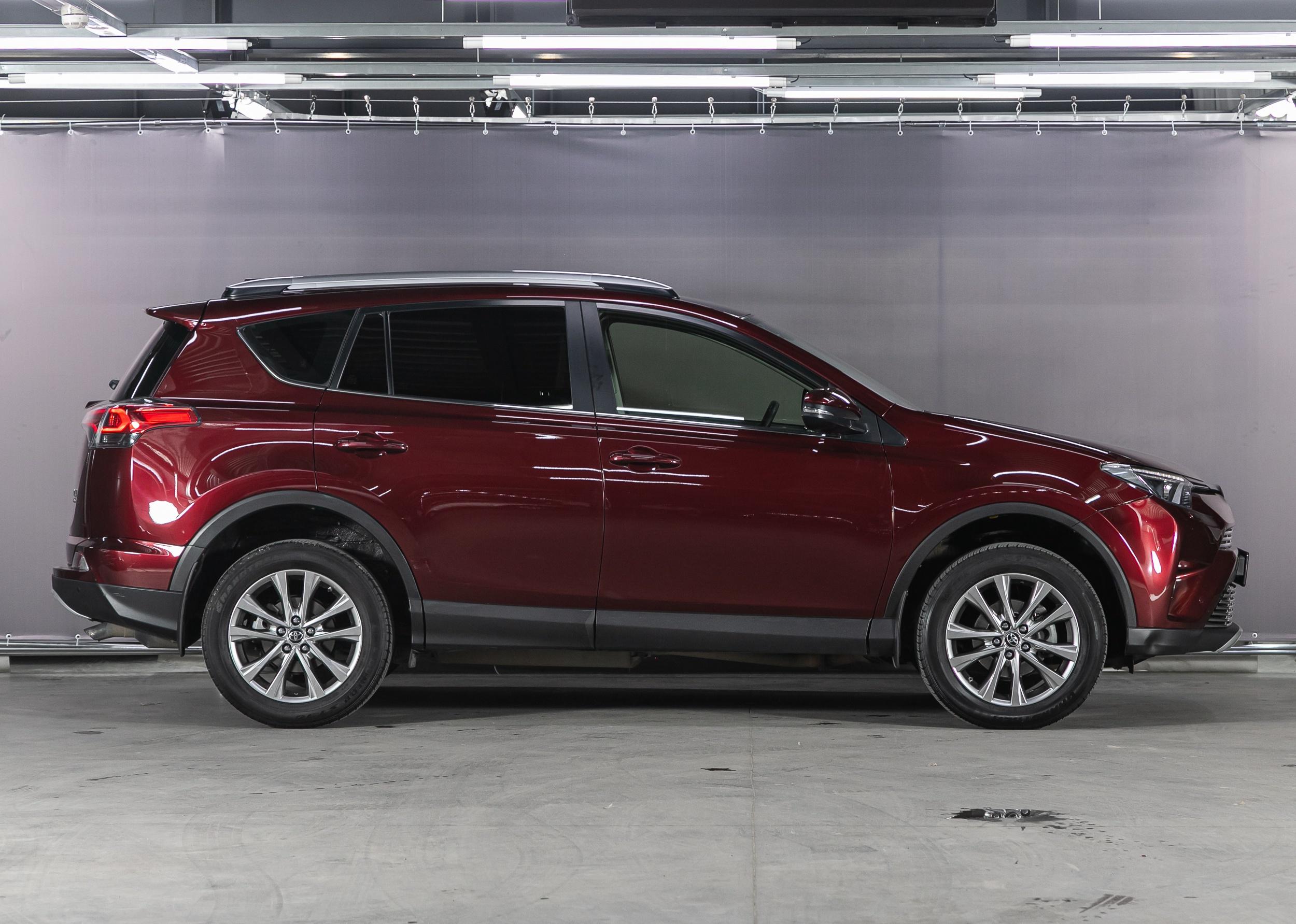 Red Toyota RAV-4, side view.