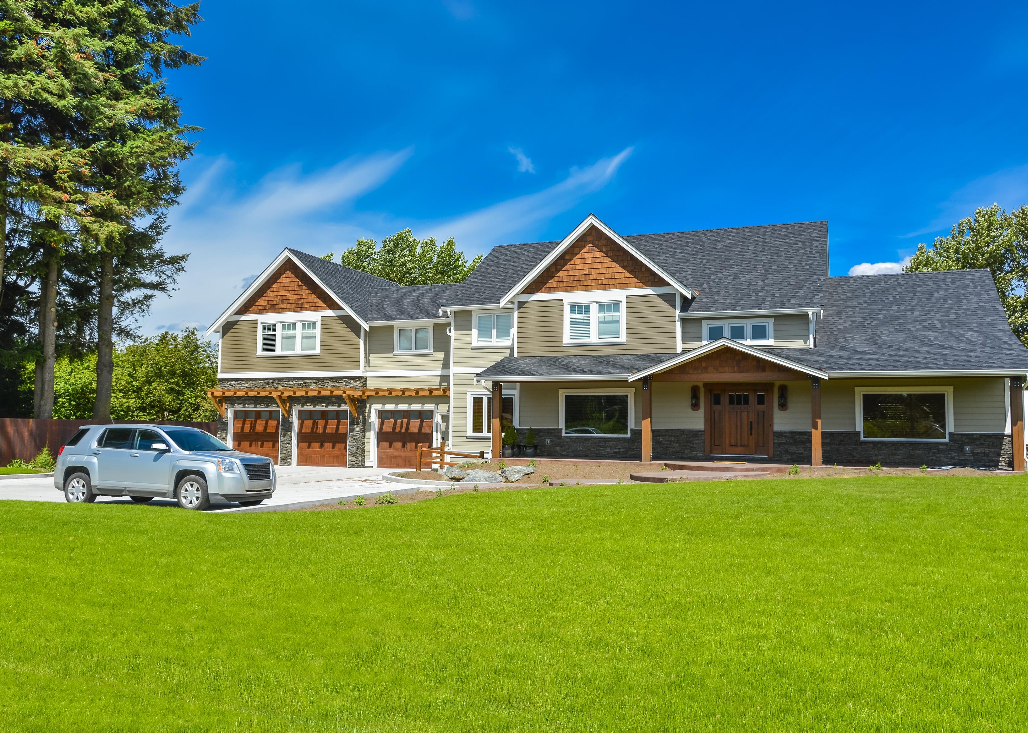 Brand new farmer's house with car parked on driveway in front. 