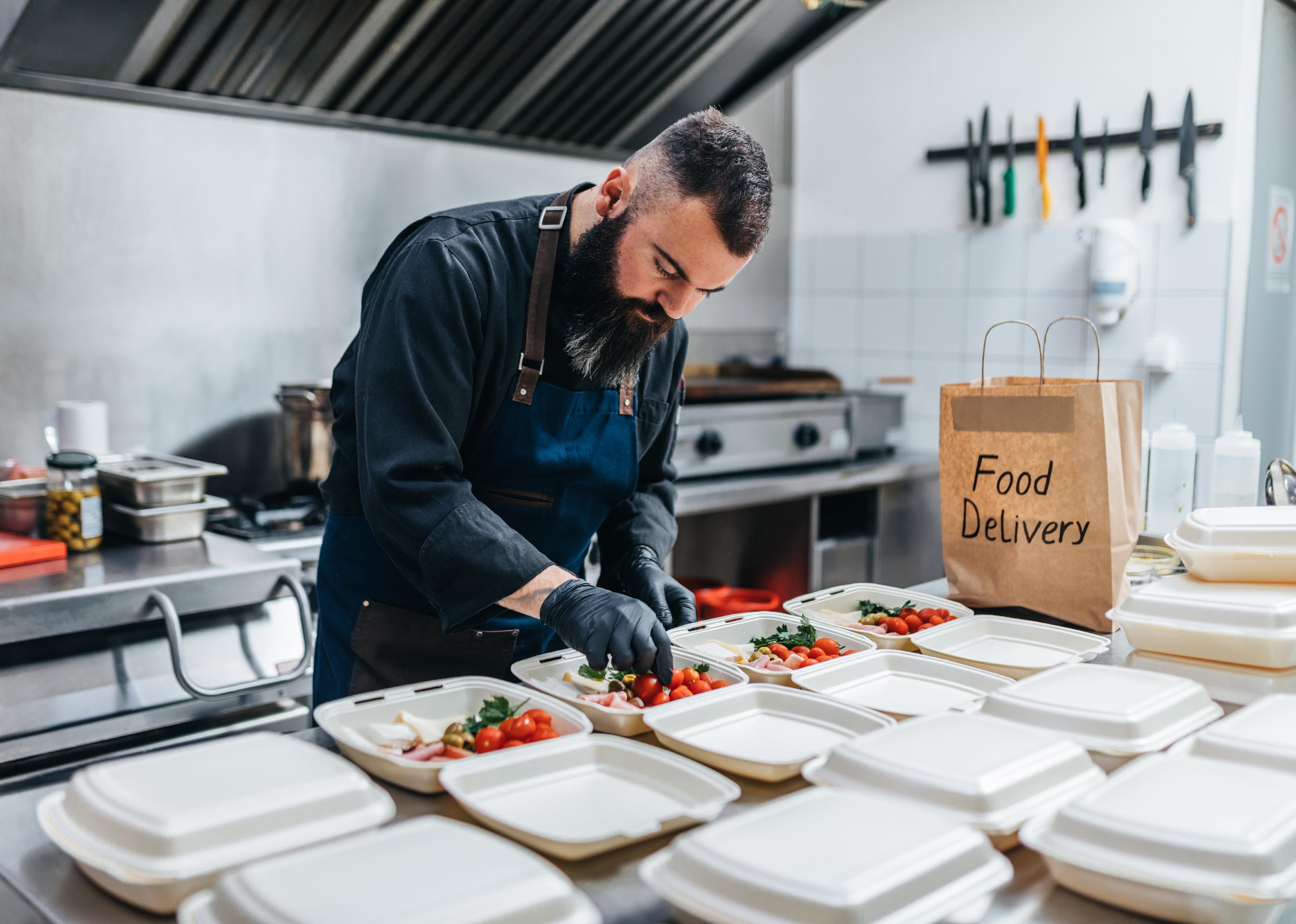 A chef prepares food disposable boxes.