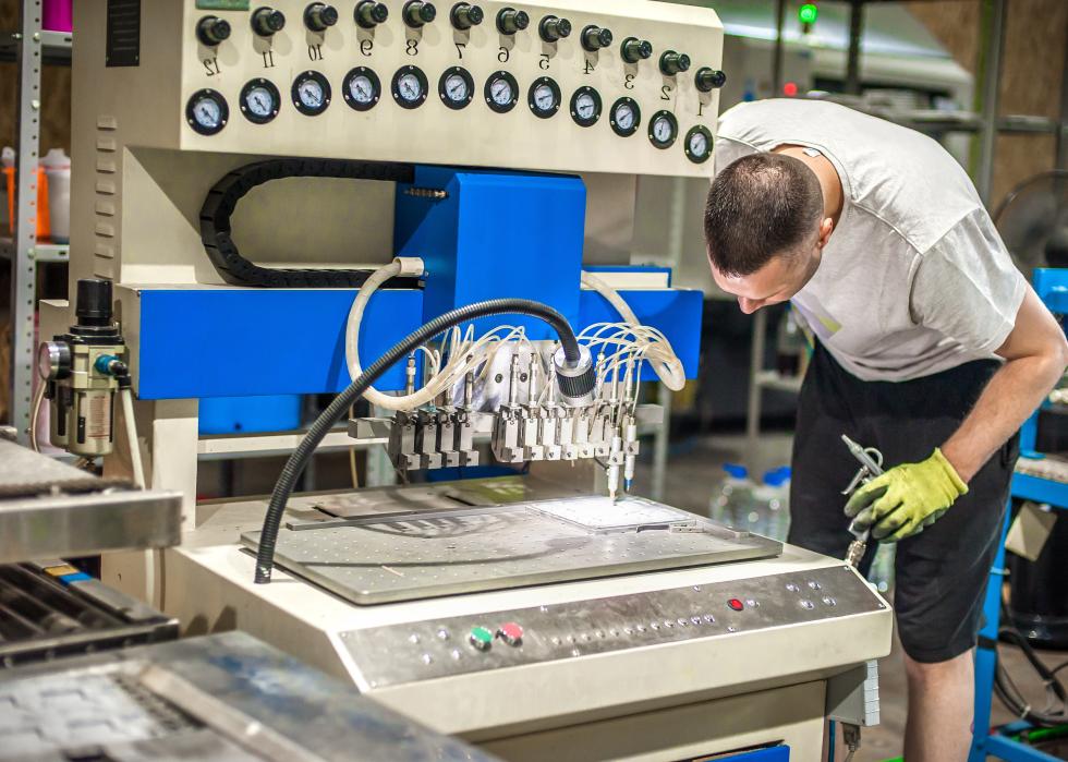 Male machinist operating with soft PVC dispensing machine