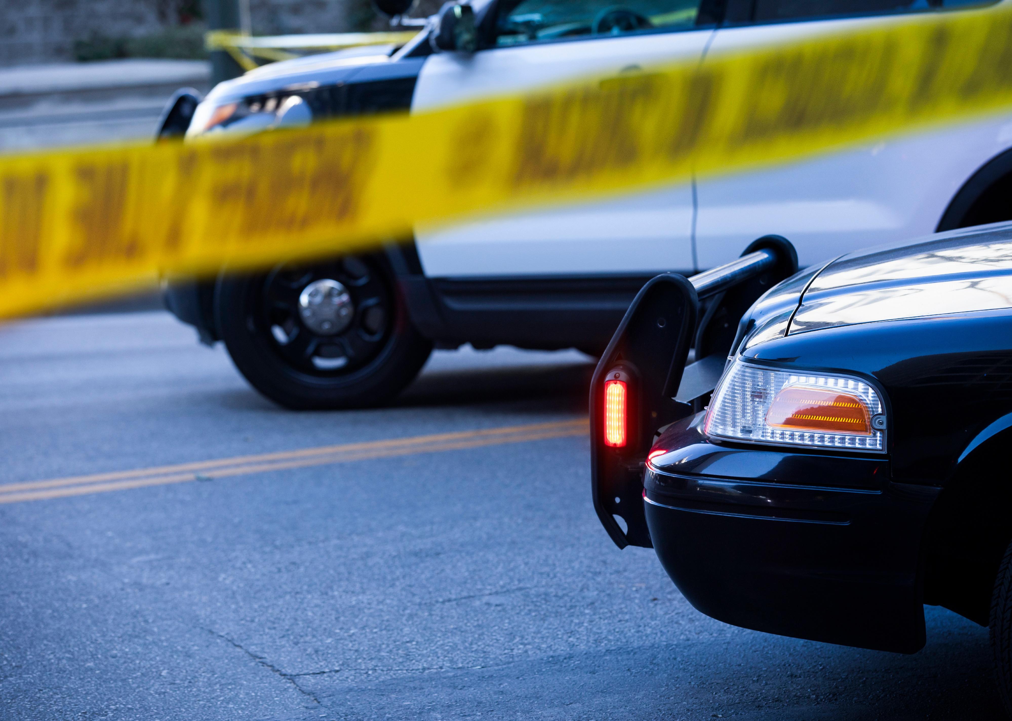 Detail view of illuminated police lights and cordon tape.