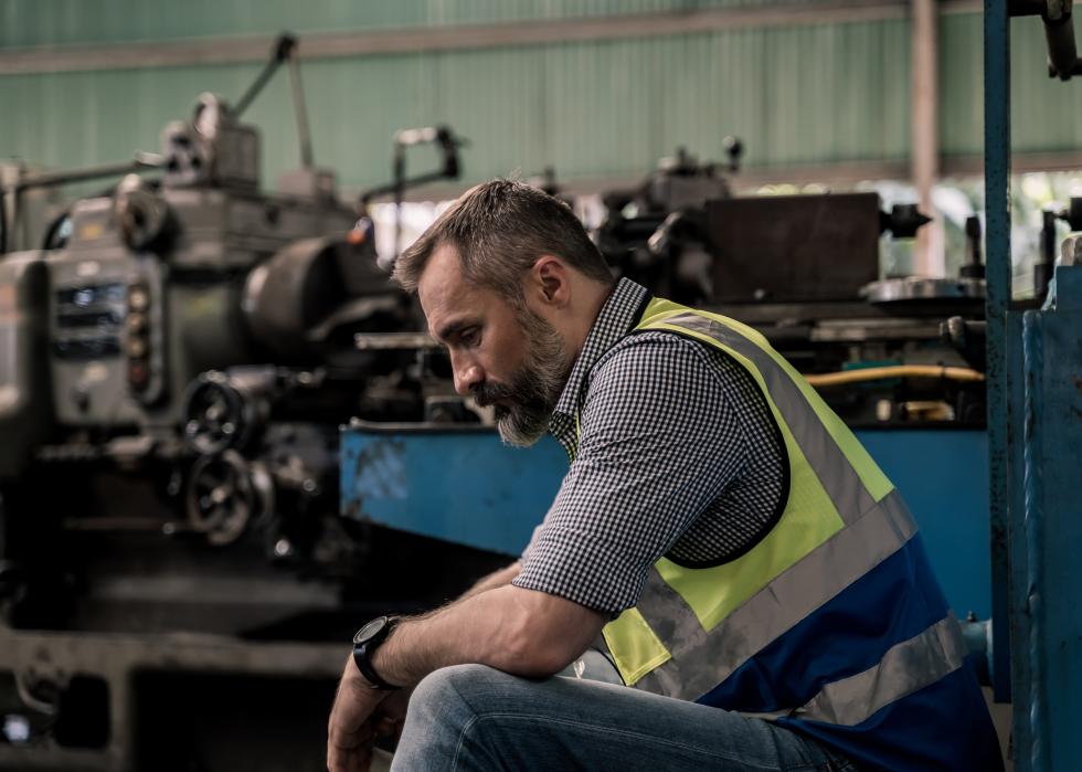 Worker in factory sitting down for a break.