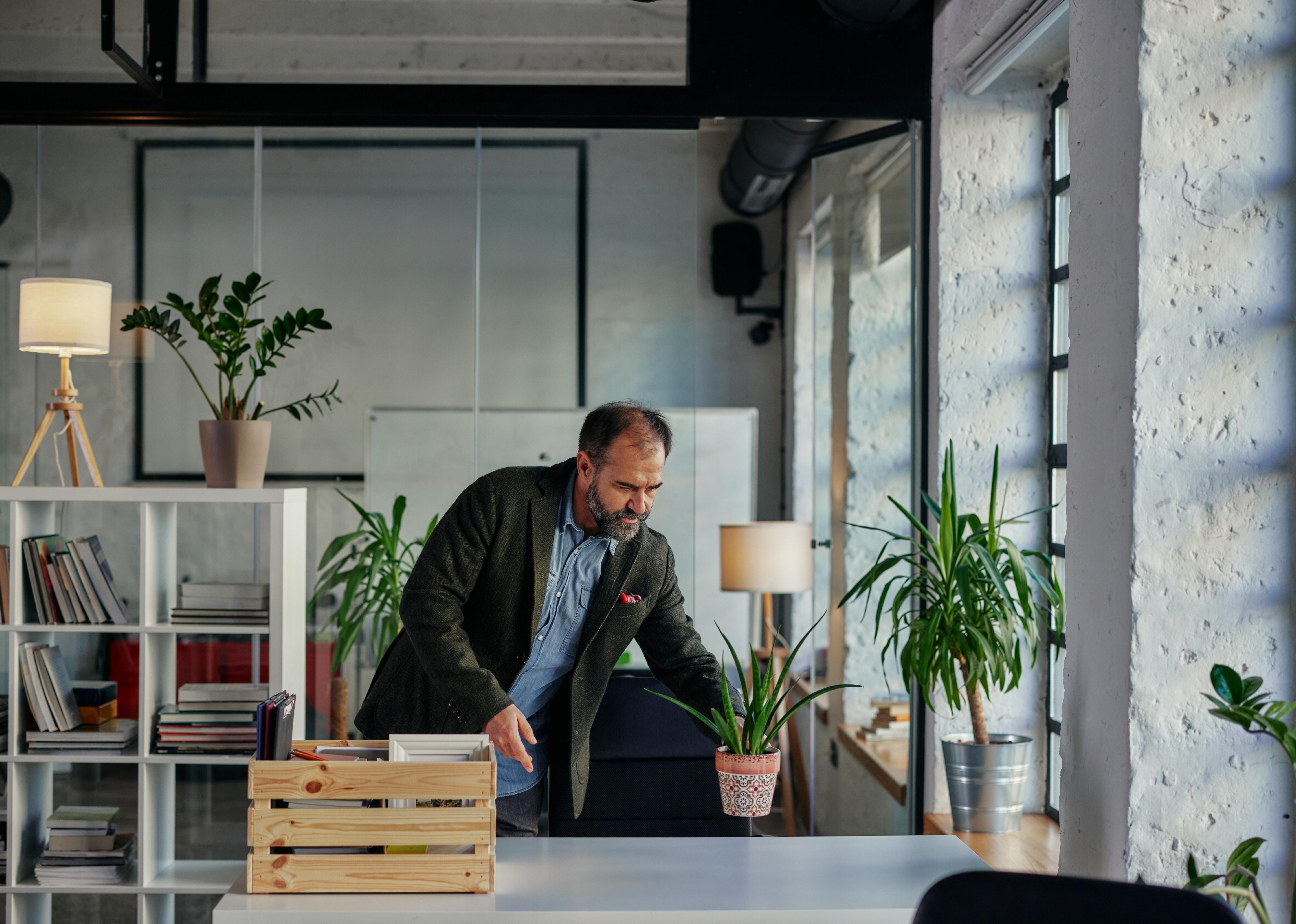 Businessman with crate box full of office supplies.