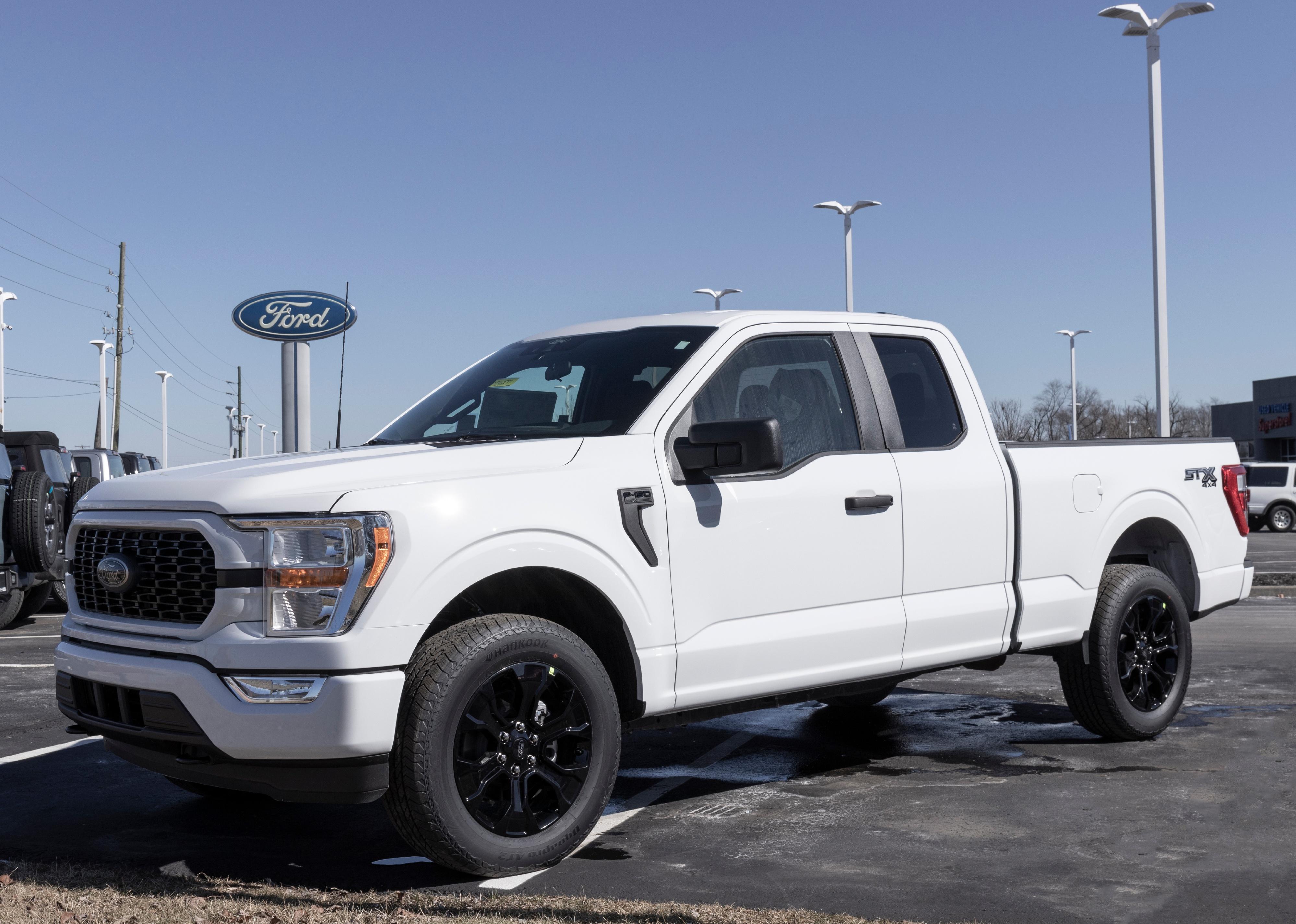 White Ford F-150 don isplay at a dealership.