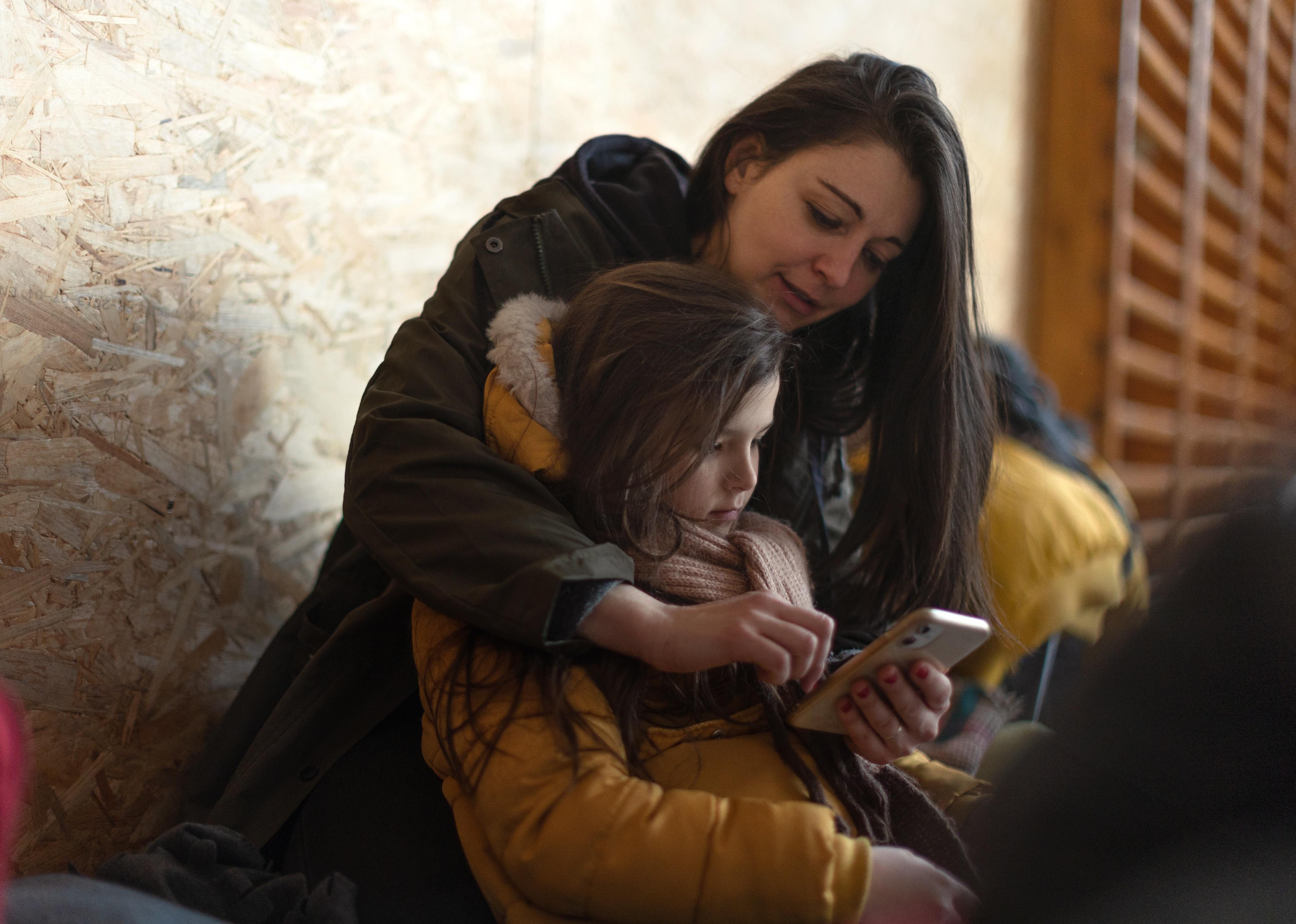 Little girl with her mother in a shelter.
