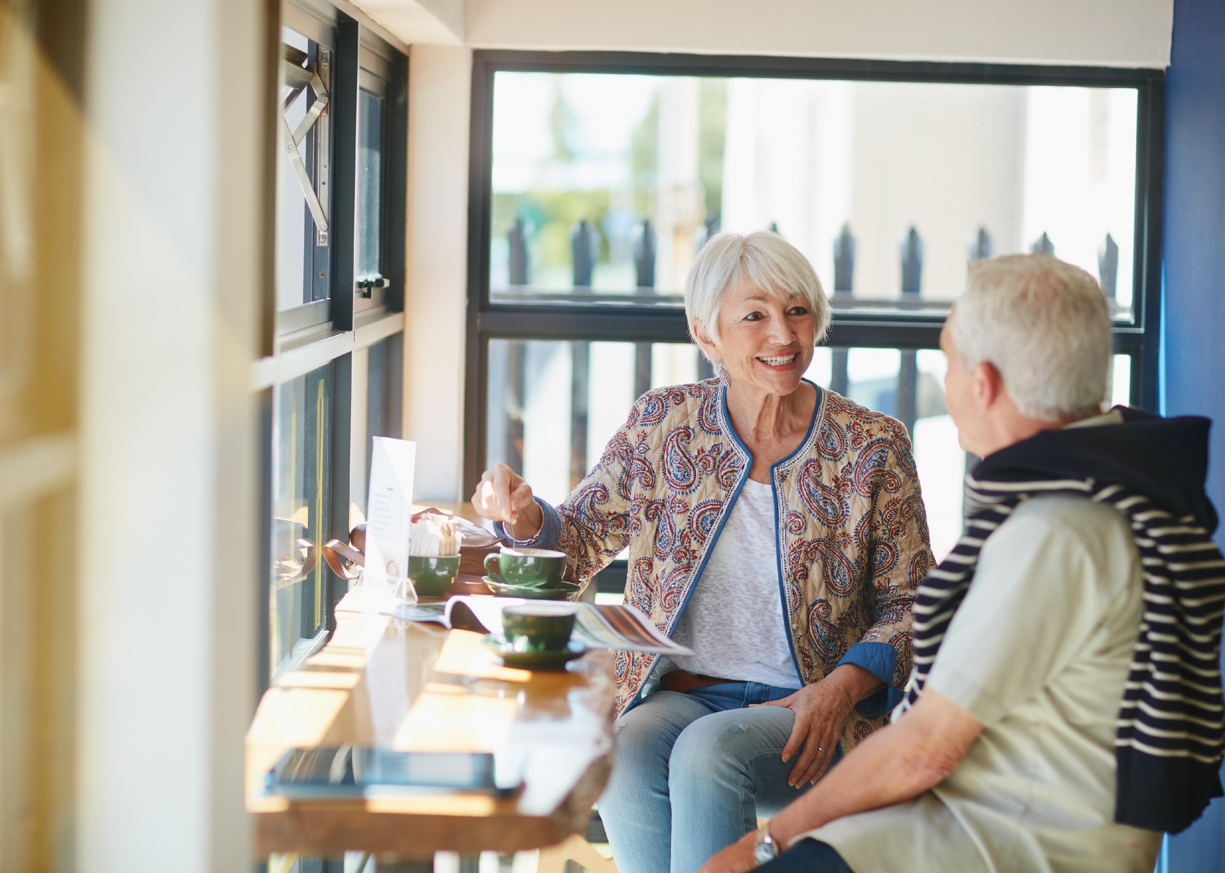 Shot of a smiling senior couple taking together in a cafe.