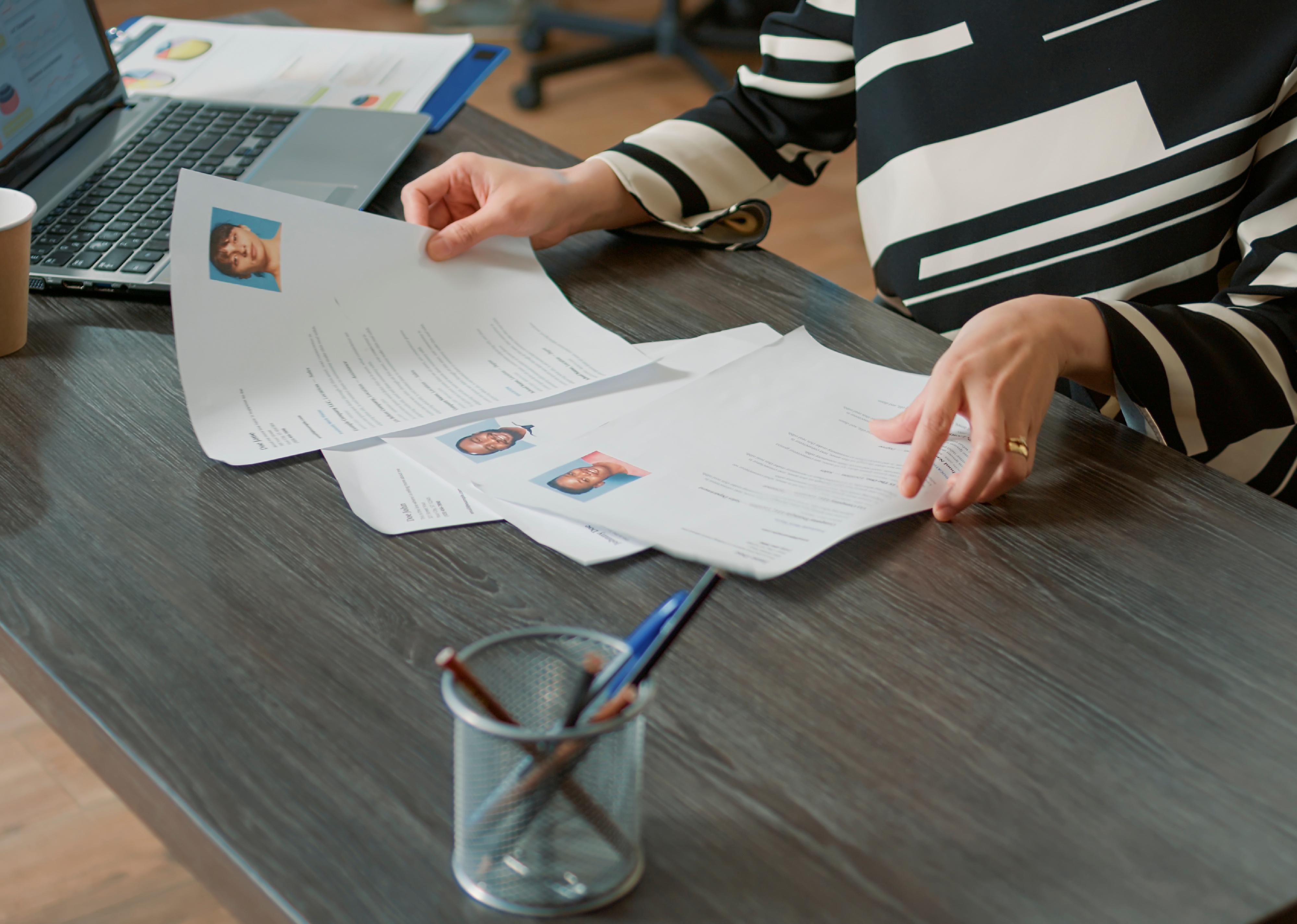 Close up of a woman reviewing CVs