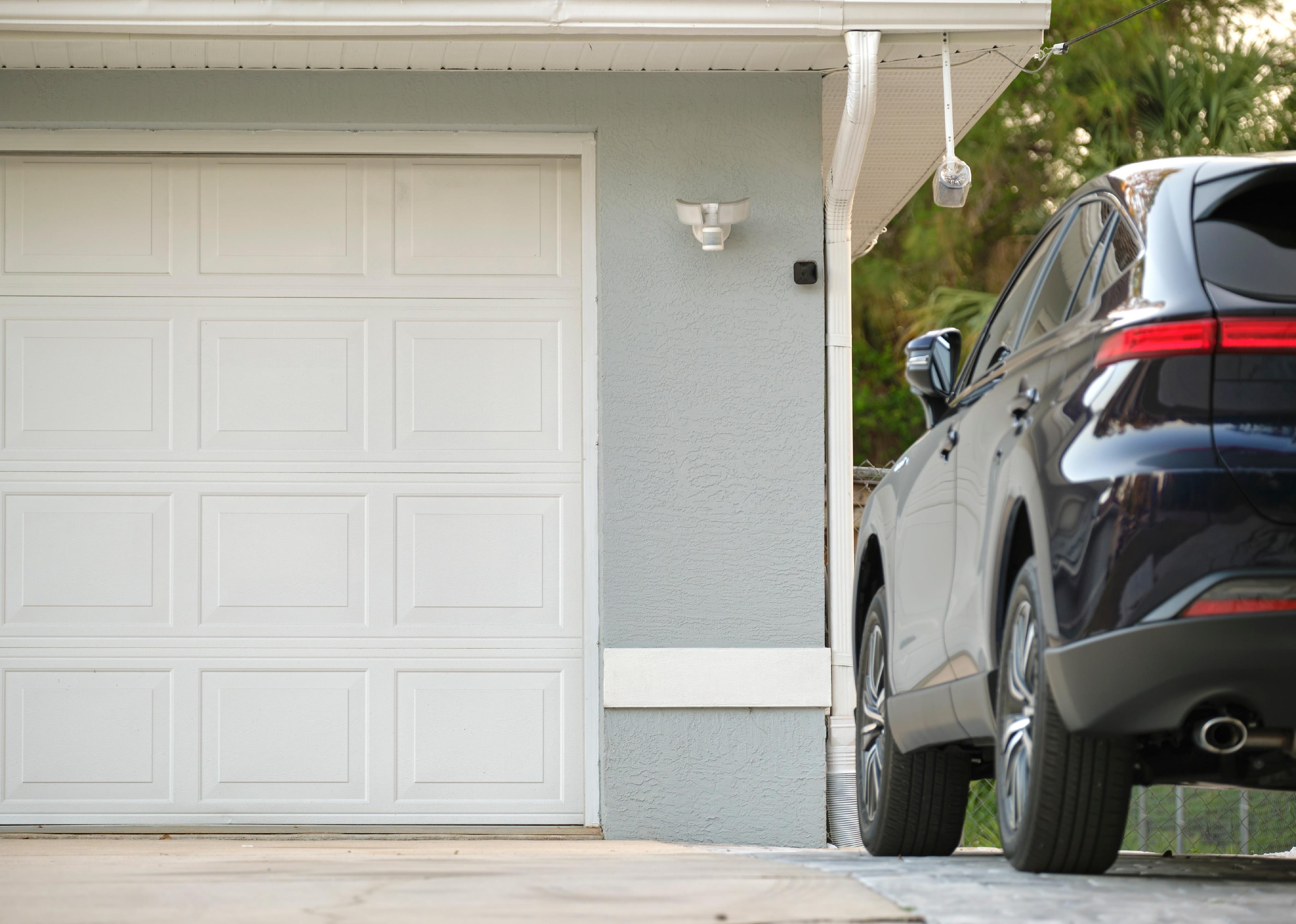 Car parked in front of wide garage double door.
