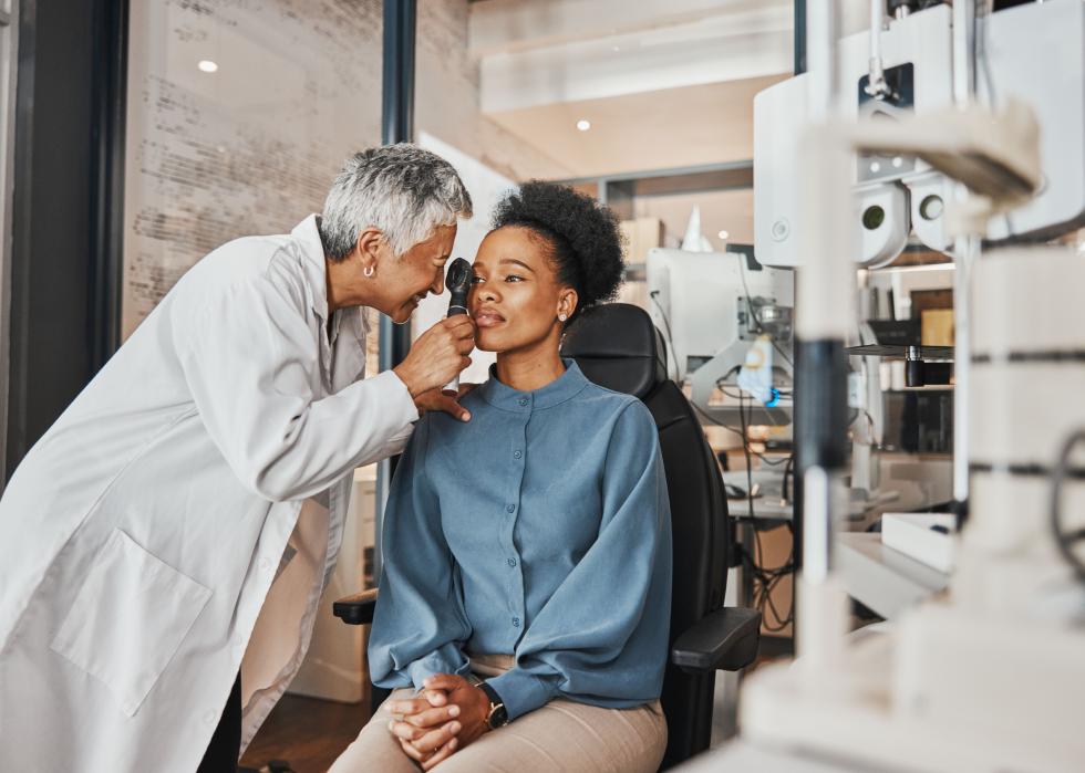 Senior optician checking iris of patient.