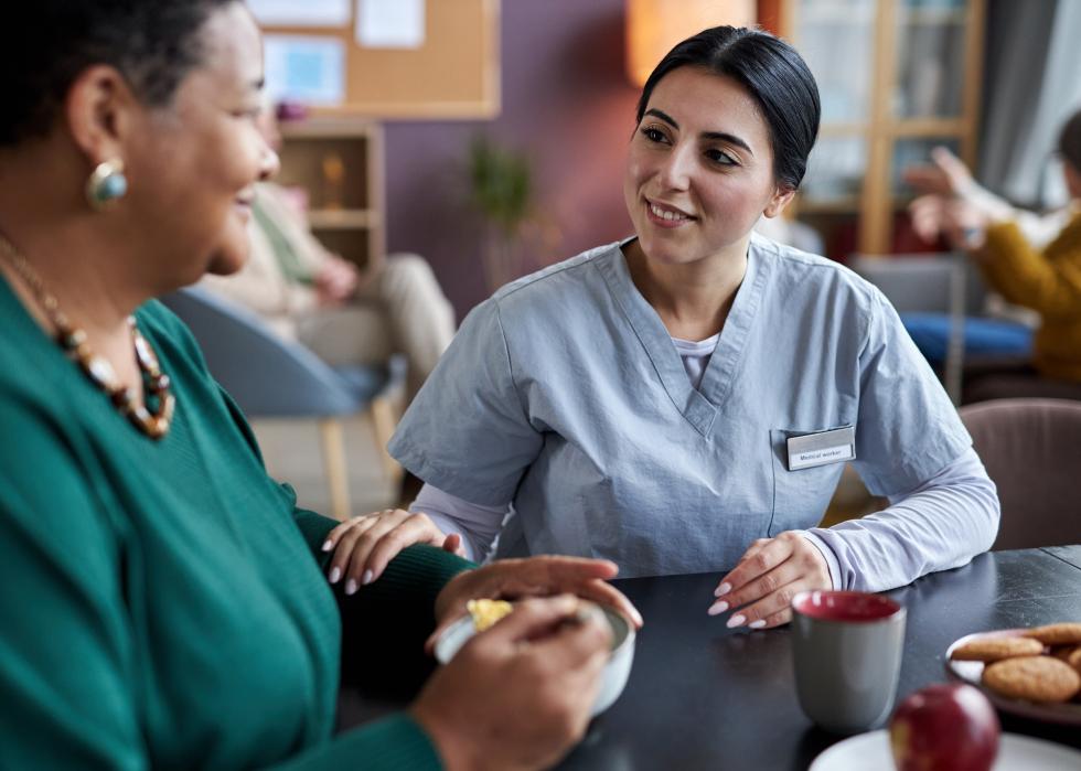 Young nurse talking to senior woman at an assisted living facility.
