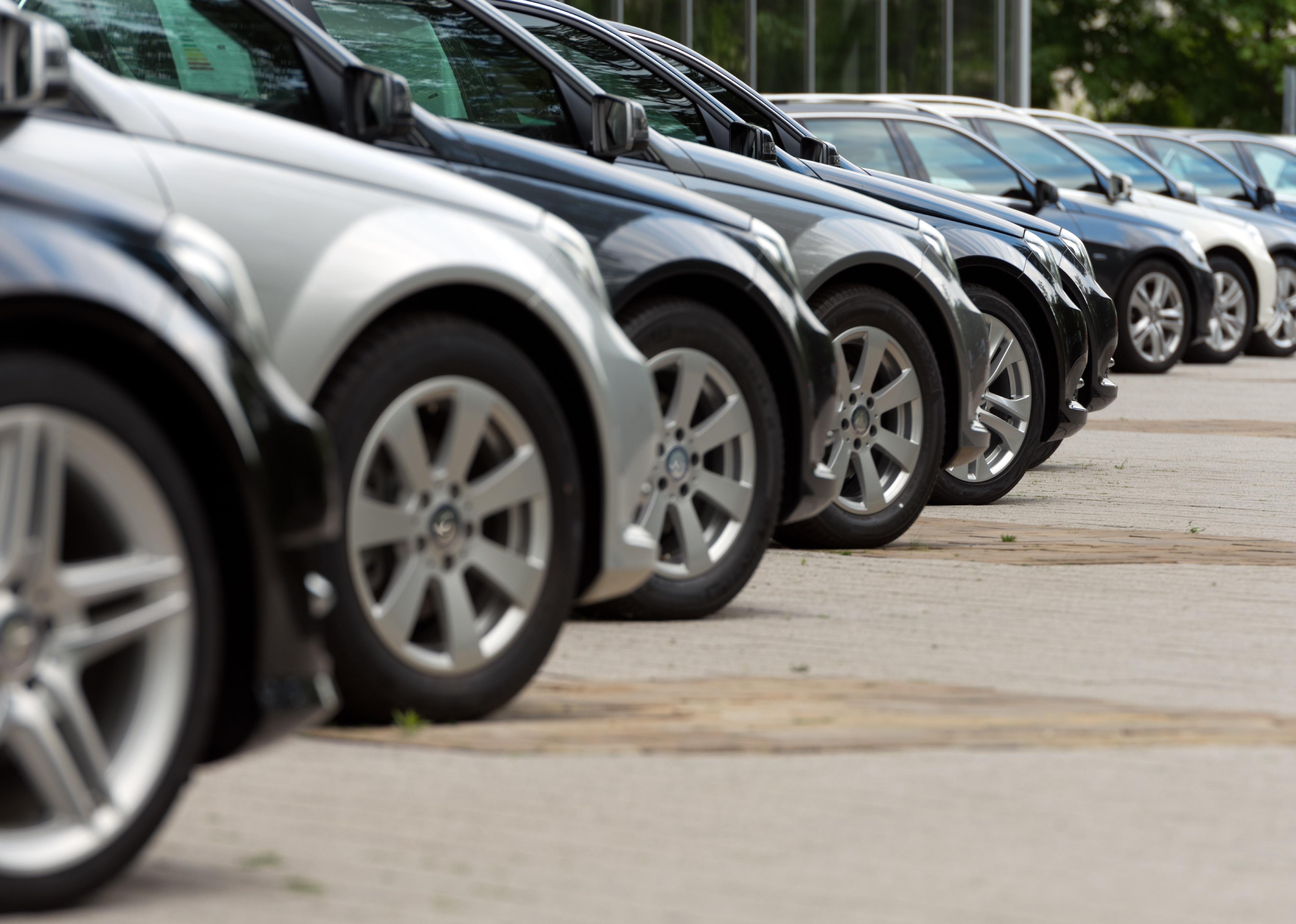 Cars for sale parked in a row.