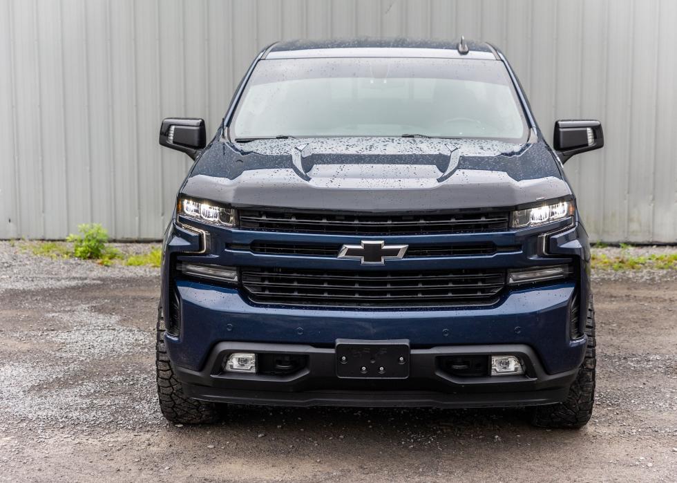 A blue Chevrolet Silverado pickup truck parked in a grassy field.