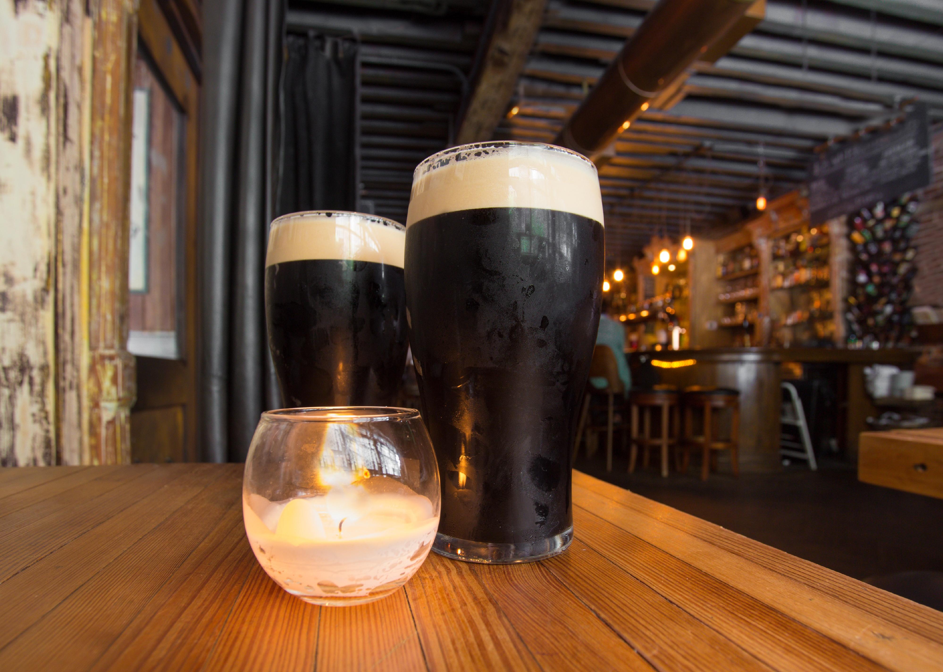 Dark beer and candle in pub setting