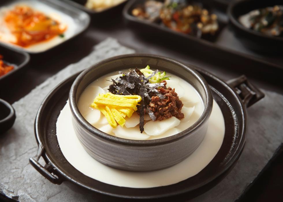Tteokguk prepared with slices of rice cake, beef, eggs.