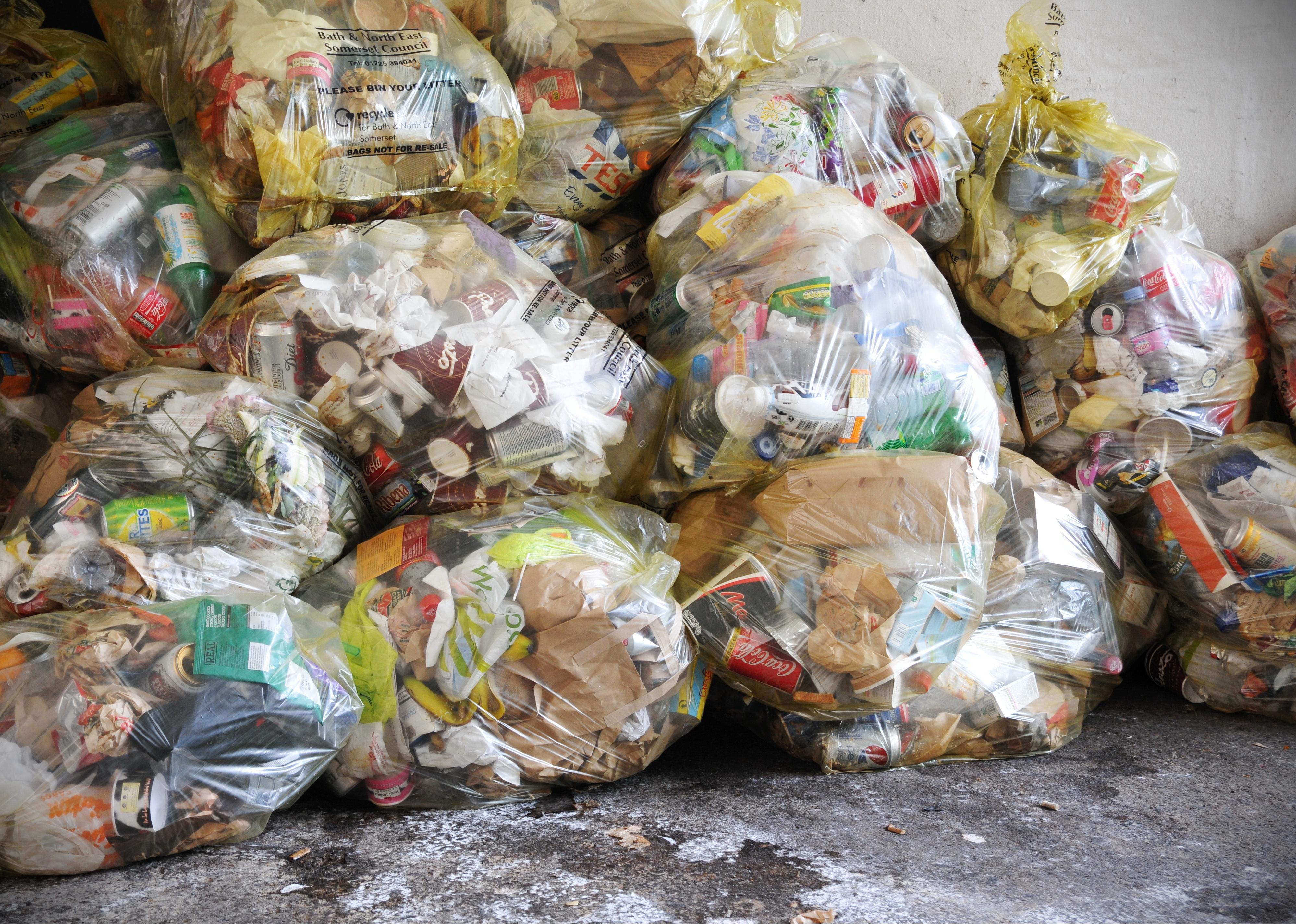 View of bagged garbage on a city center street.