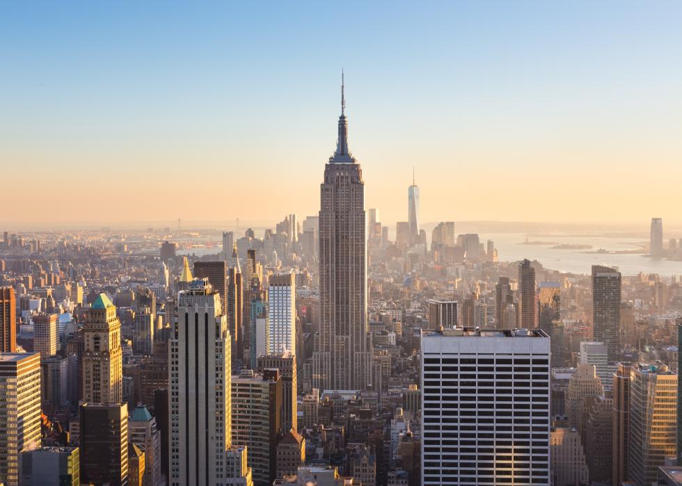 Manhattan downtown skyline with illuminated Empire State Building and skyscrapers.