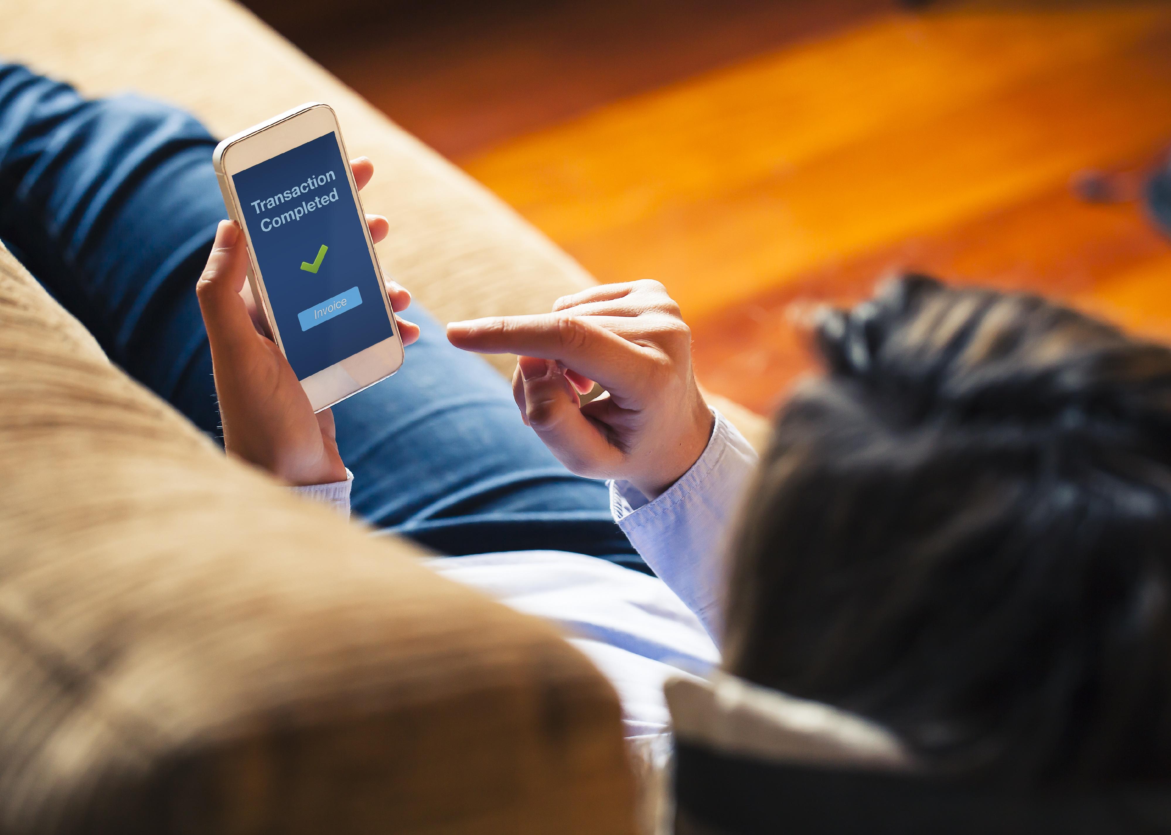 Woman lying on couch, holding phone
