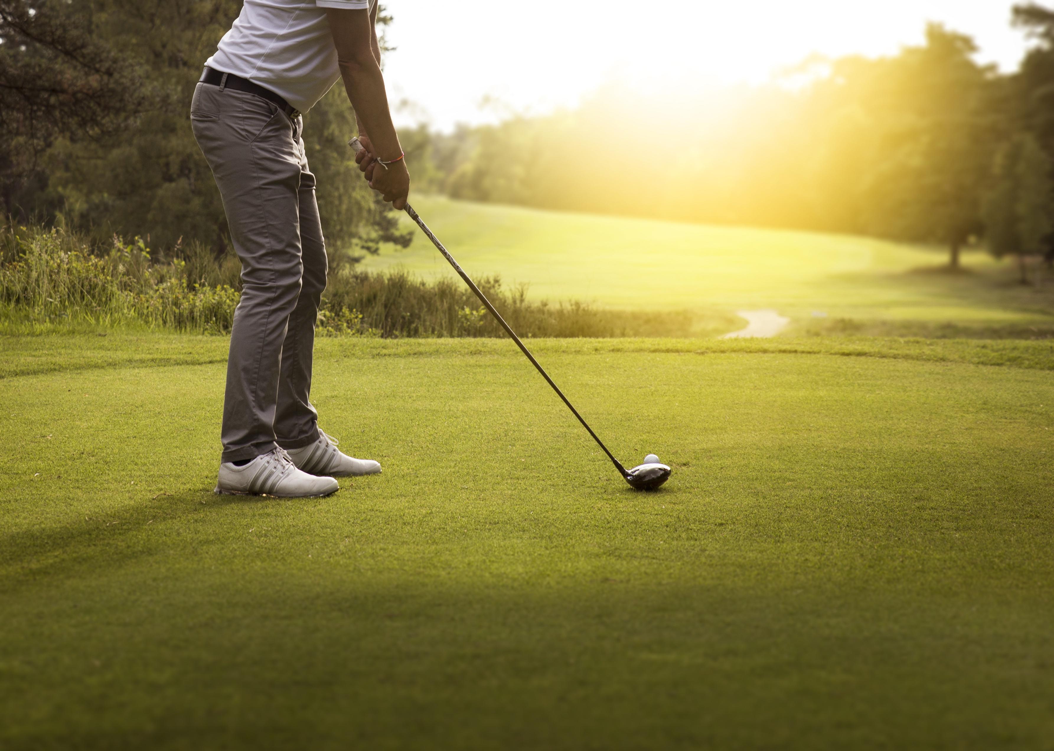 Person playing golf with sun streaming in.