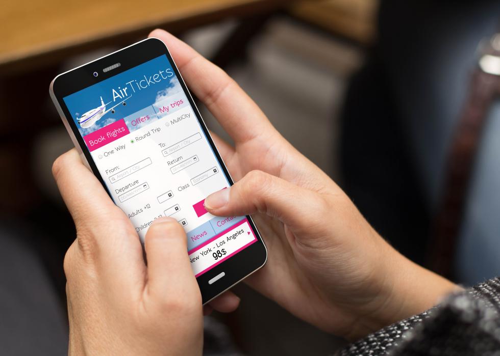 A girl using a phone to book flight tickets.