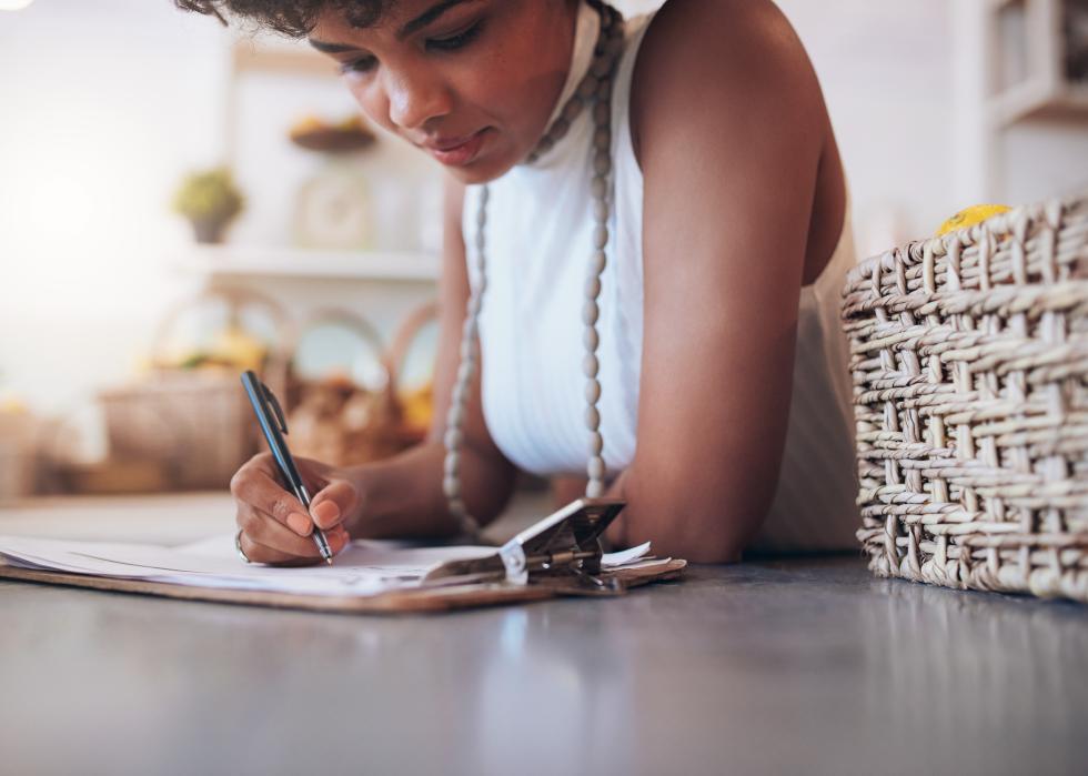 Female standing behind the counter and writing notes
