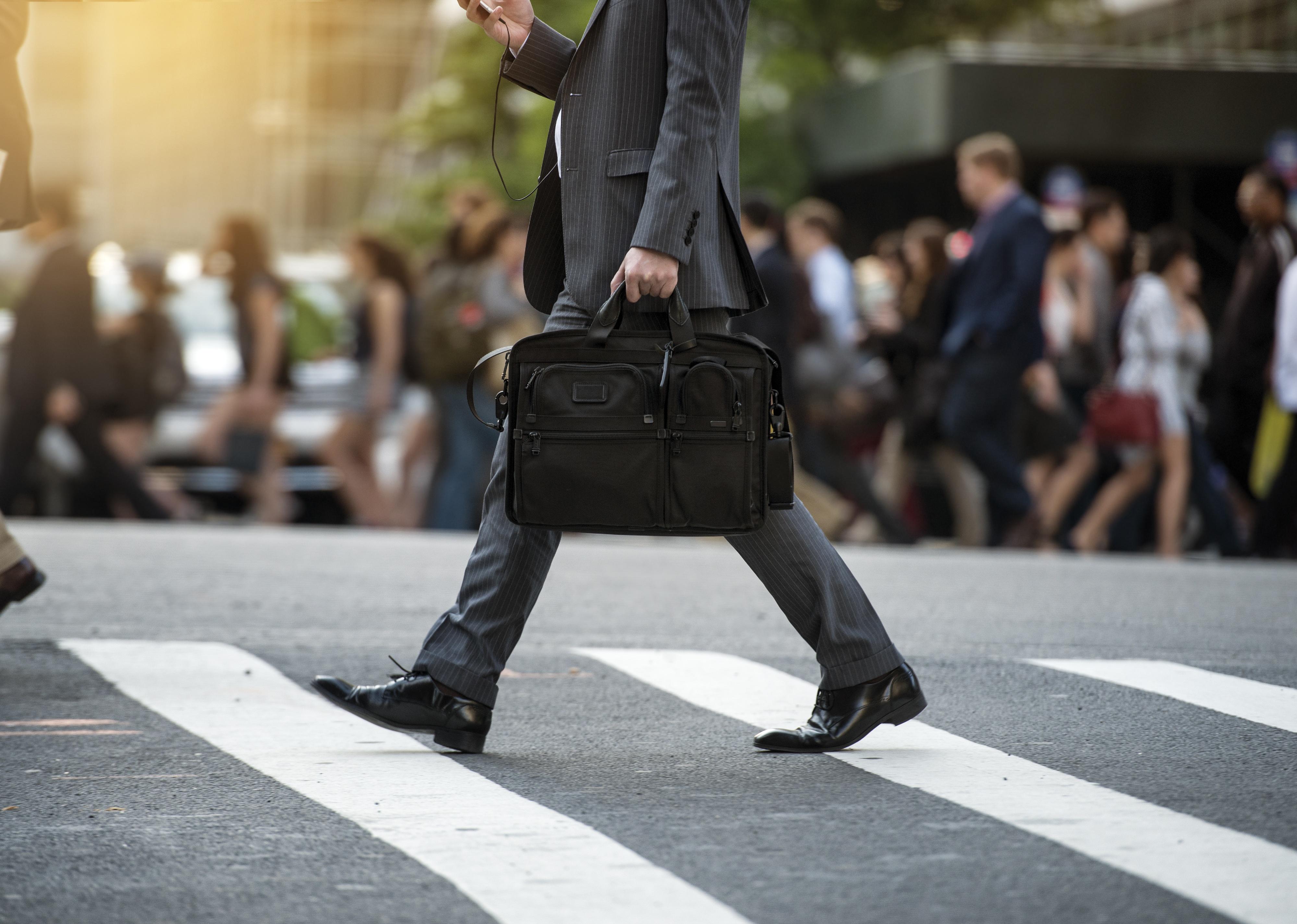 Businessman crossing the street on crosswalk