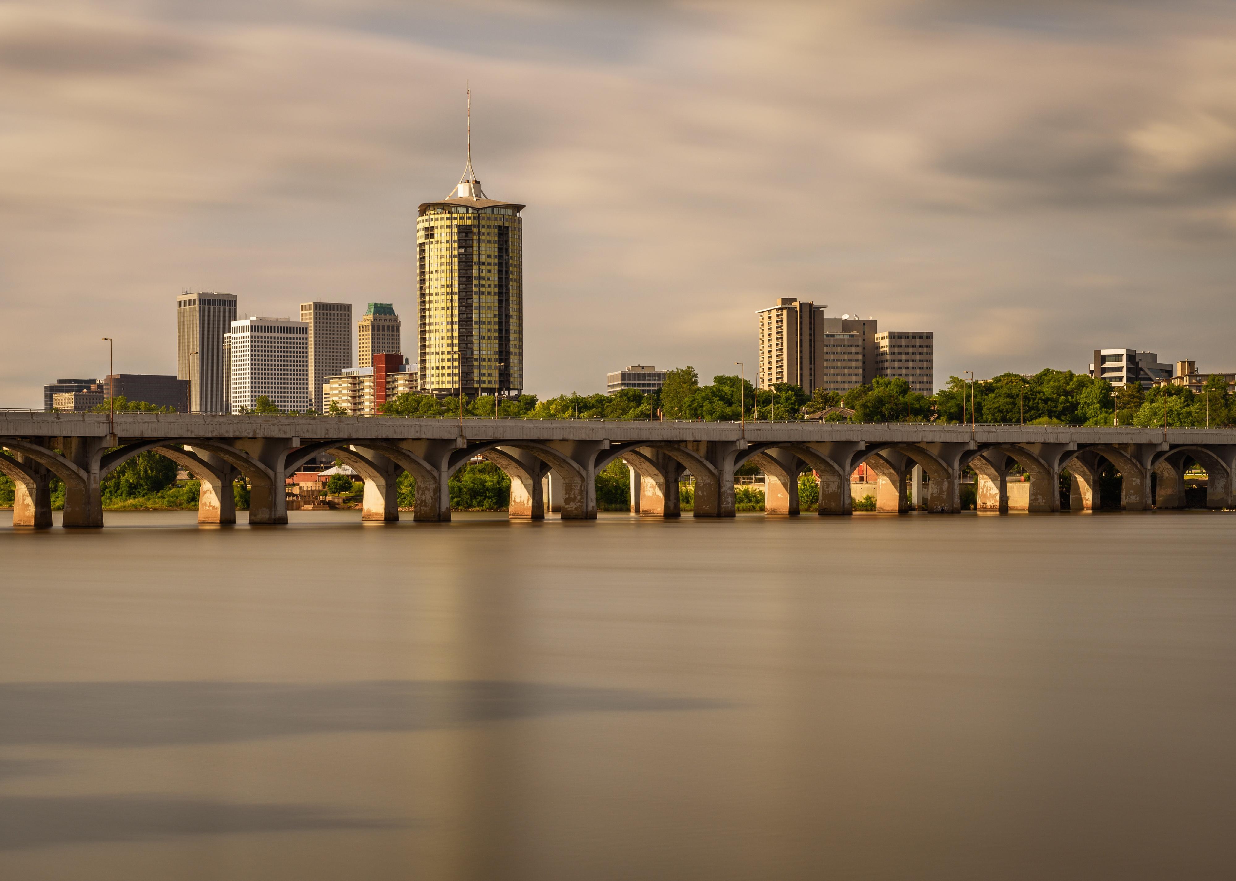 Sunset skyline of Tulsa, Oklahoma with Arkansas River in the foreground.