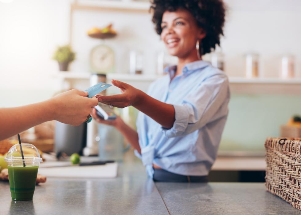 Cropped shot of female employee taking payment from customer