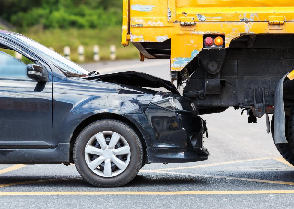 Accident on a road involving black car and yellow truck
