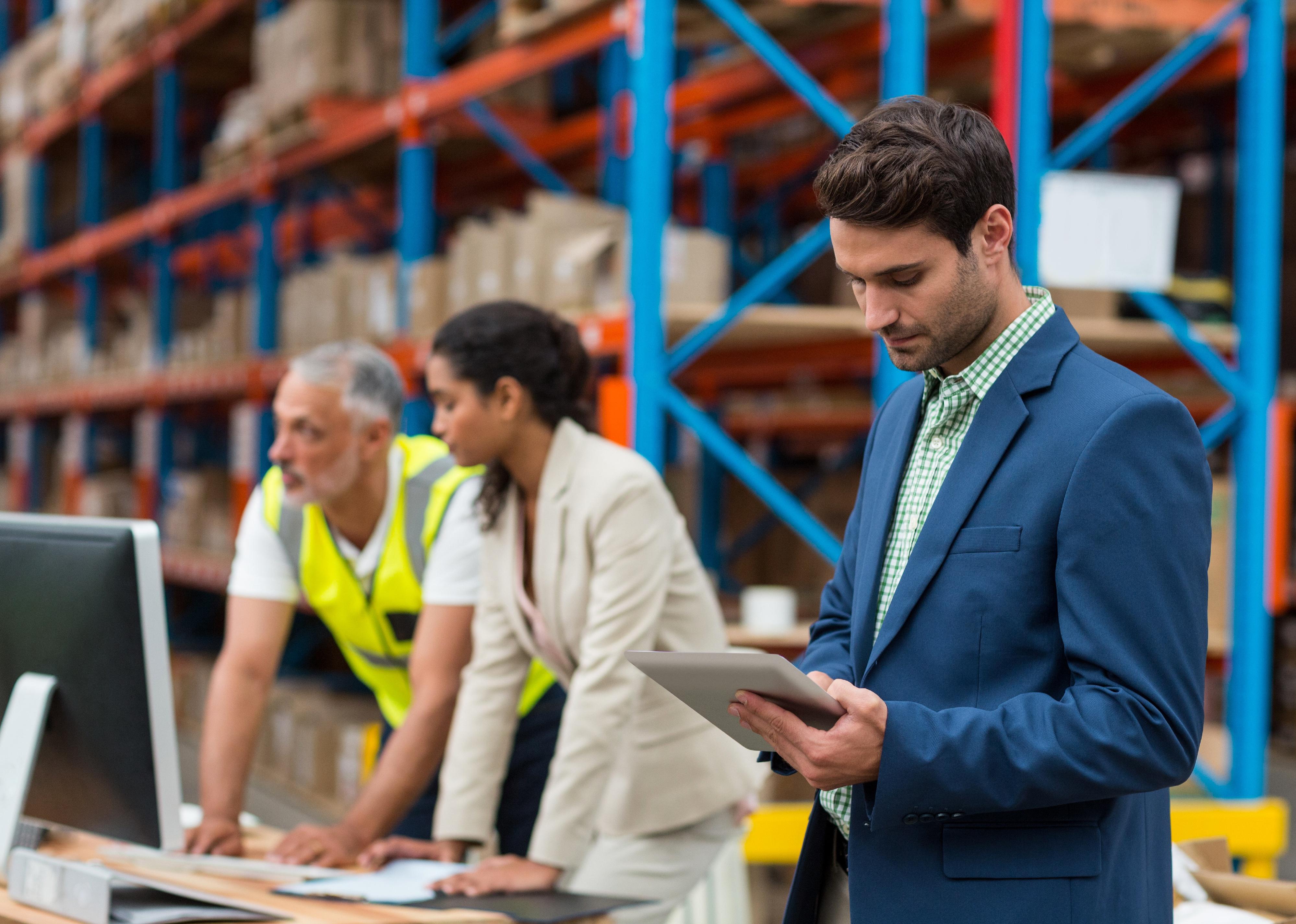 Three people working together in warehouse office