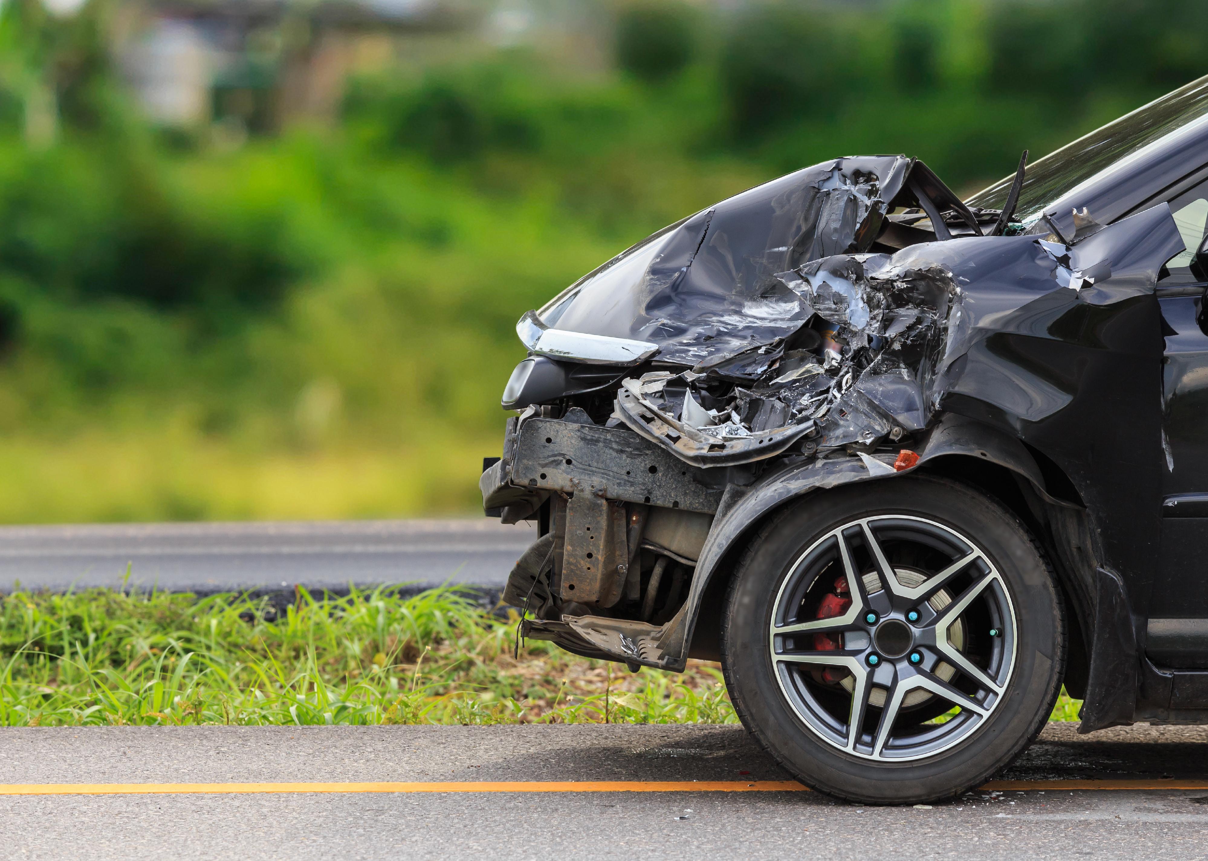 Front of black car damaged by an accident on the road