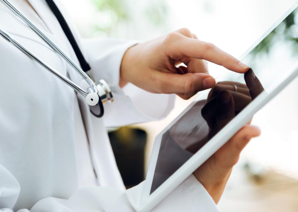 Portrait of doctor using her digital tablet in the office.