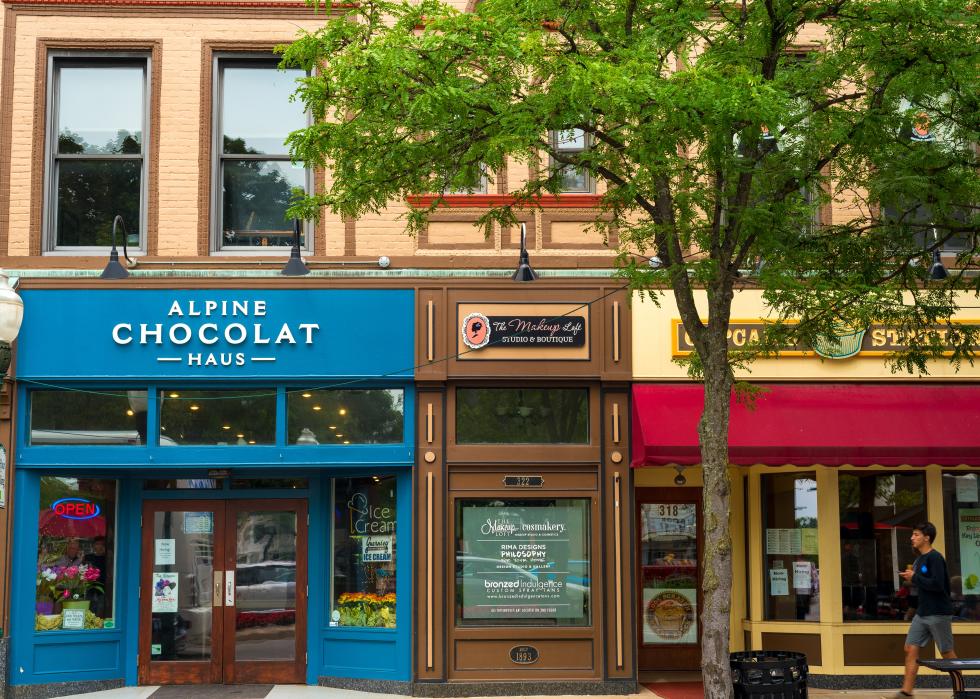 Culinary outlets, shops, and businesses line a tree-shaded sidewalk