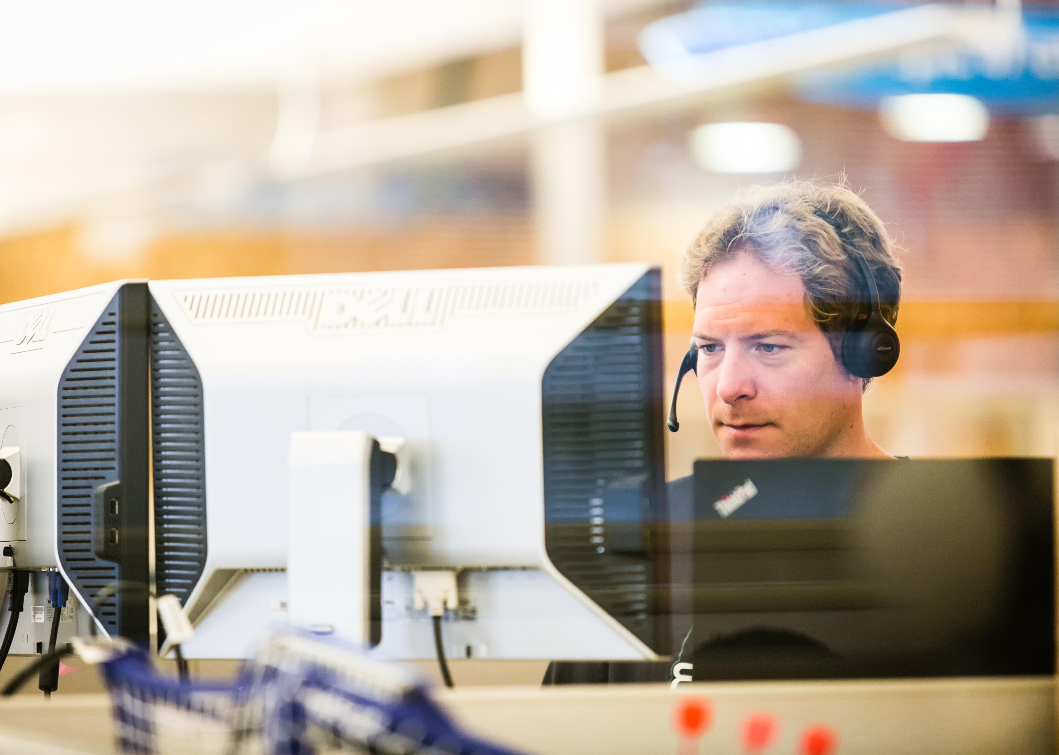 Man wearing a headset working at a technology company call center