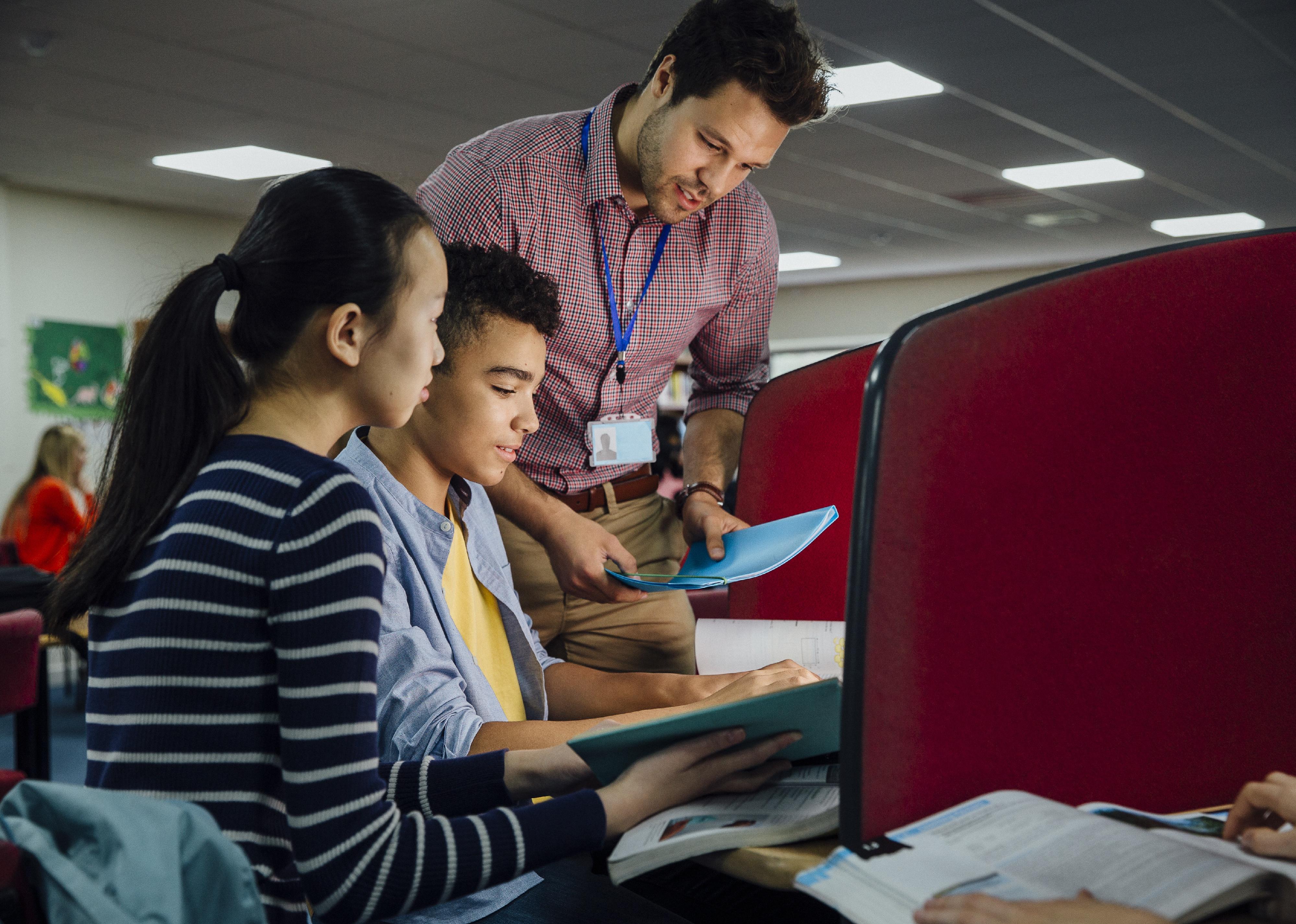 Teacher and students working by computers