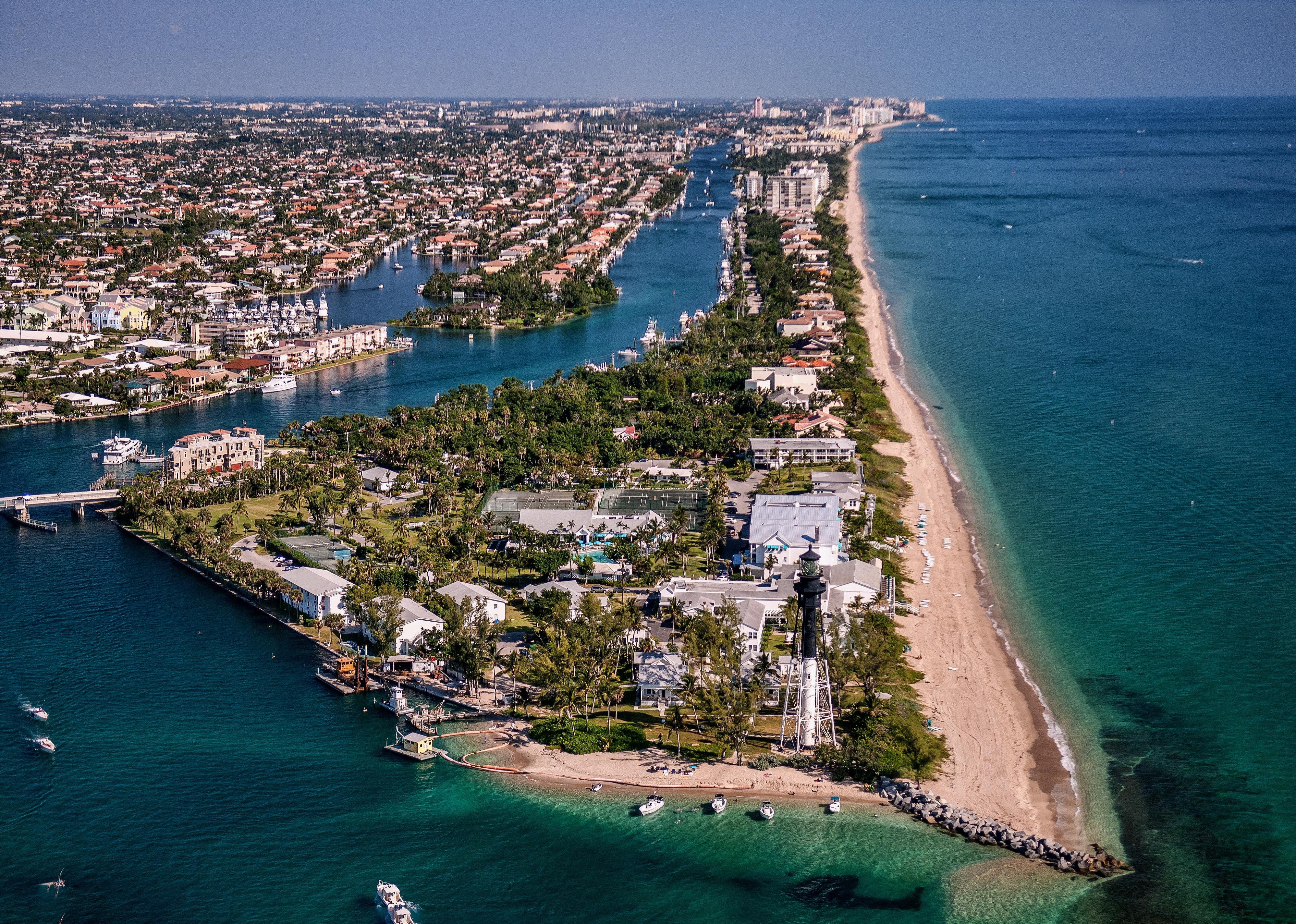 Aerial view of lighthouse and boating inlet.