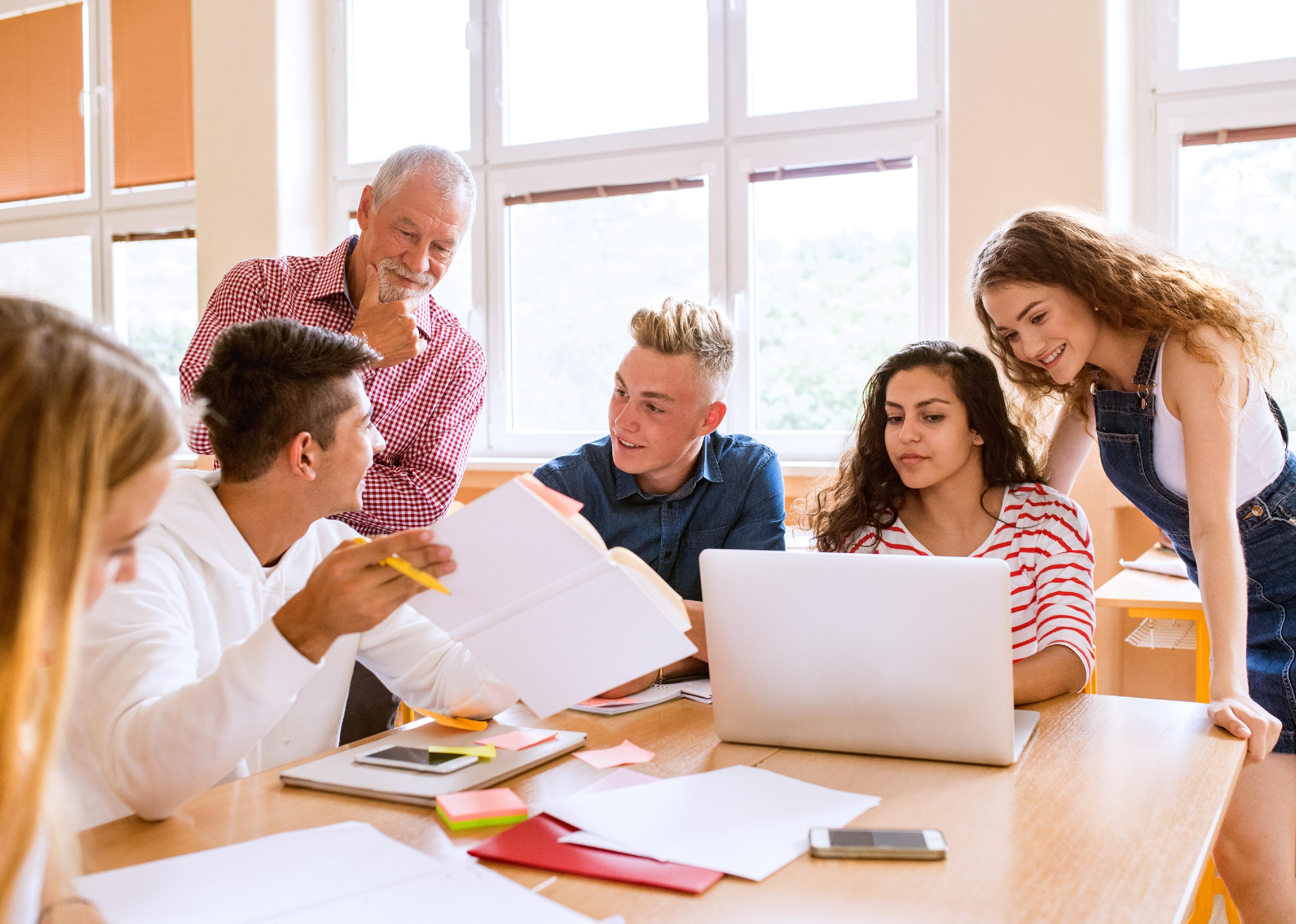 High school students and teacher with laptop