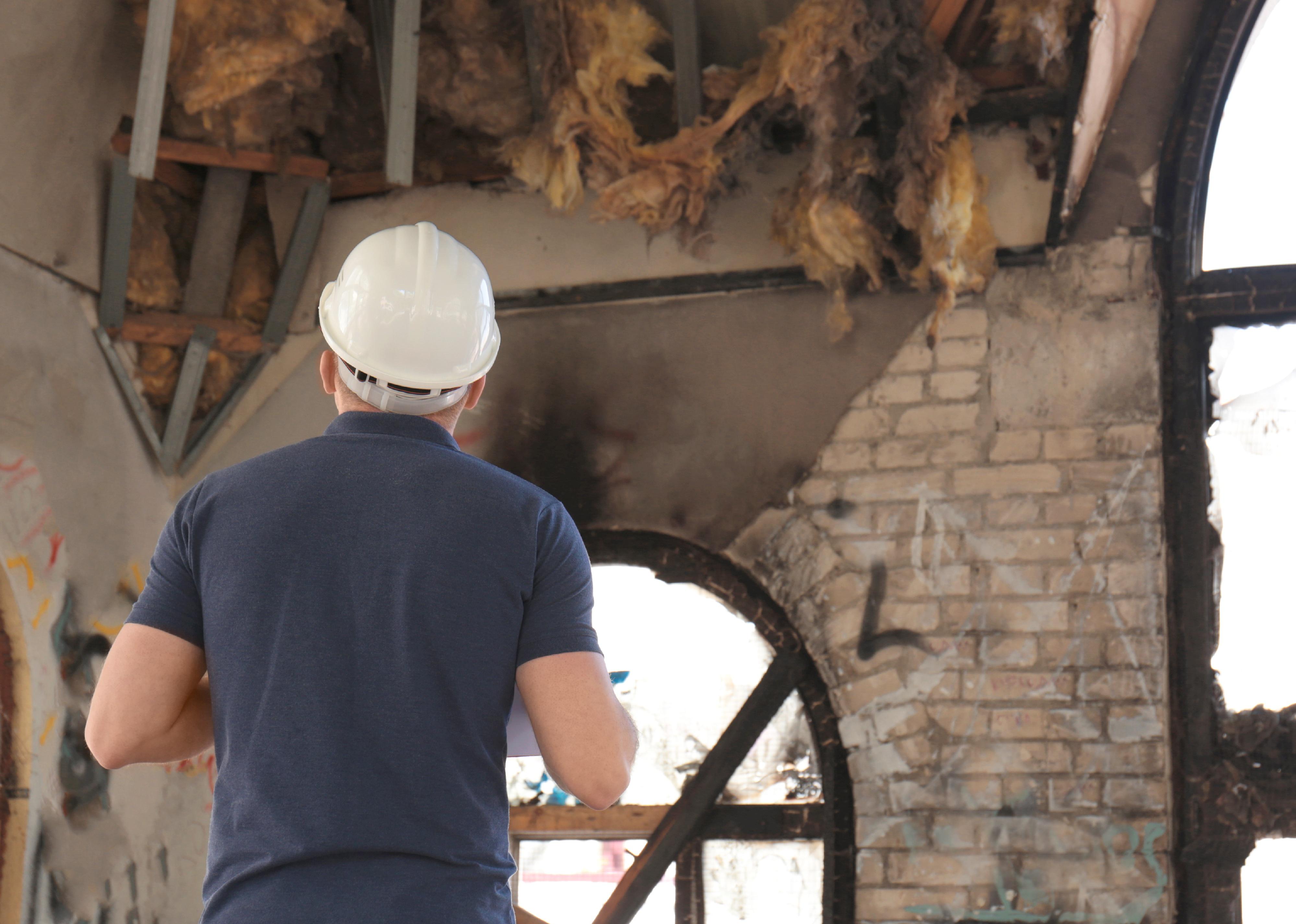 Insurance adjuster inspecting damaged building.