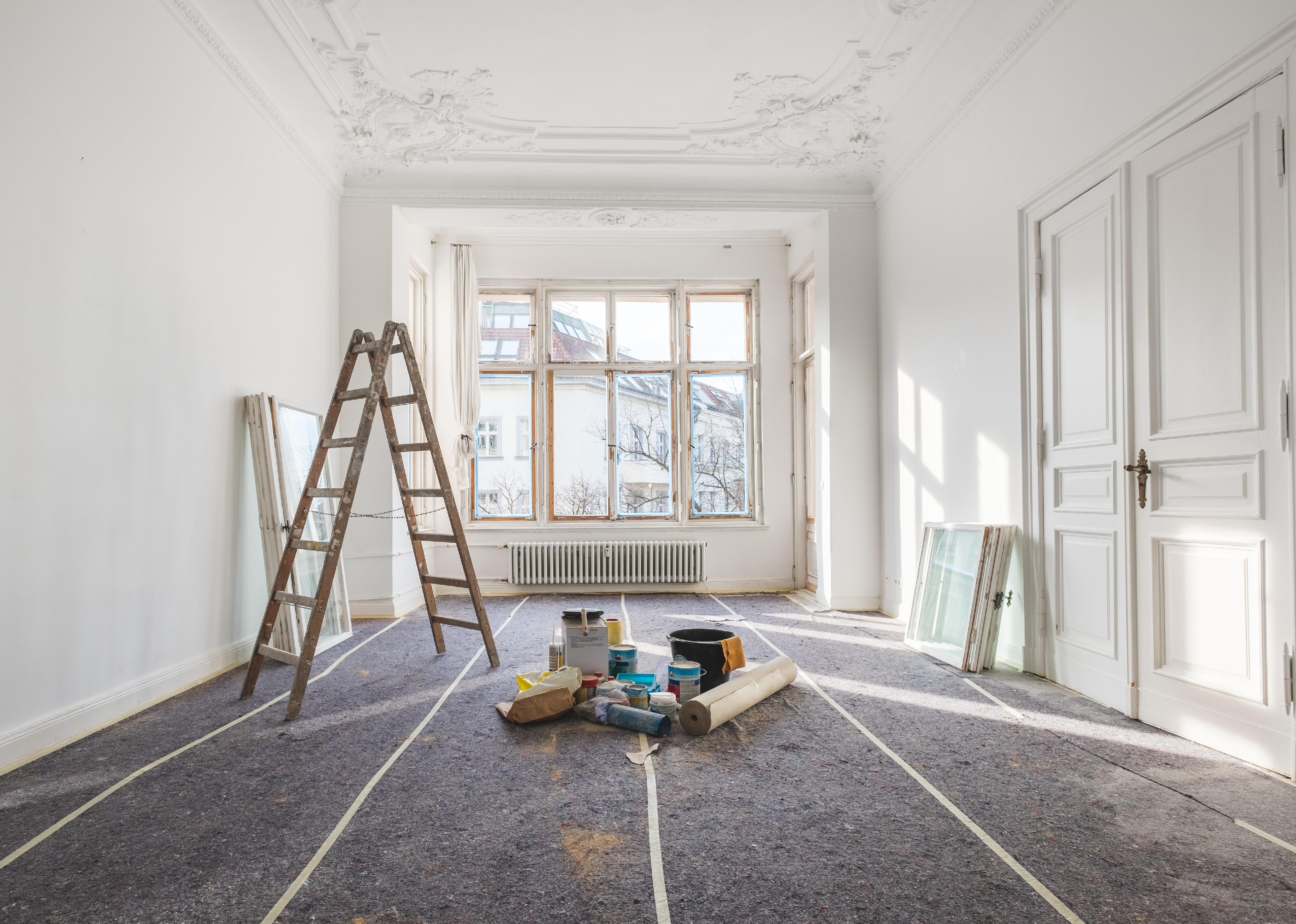 Old, empty flat with ladder and other renovation tools around.