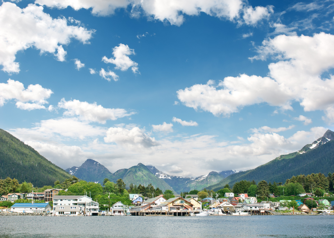 Homes on the water in Sitka with mountains in the background.