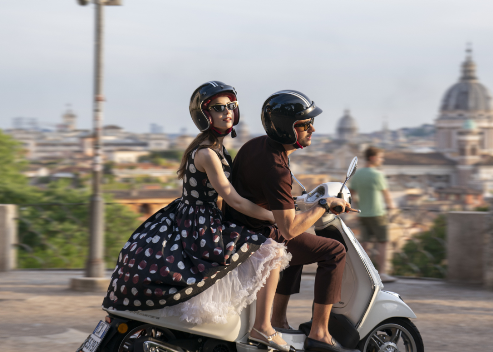 Lily Collins and Eugenio Franceschini on a scooter.