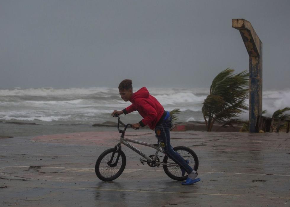 A child rides his bicycle at the seaside in Nagua, Dominican Republic, on September 19, 2022, as Hurricane Fiona passes through the country.