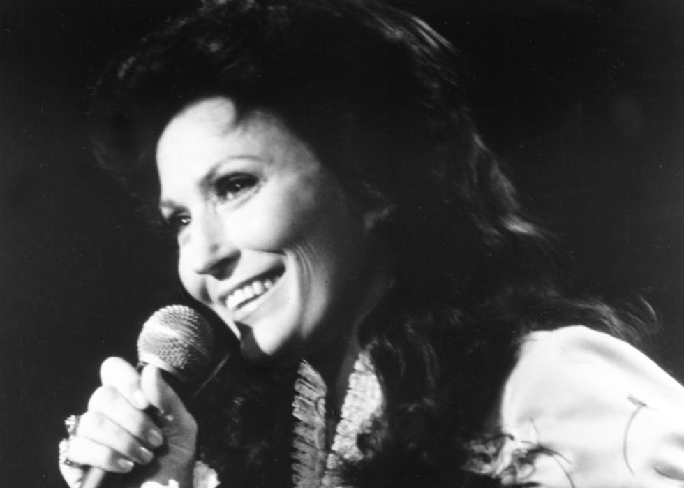 Loretta Lynn smiles with microphone.