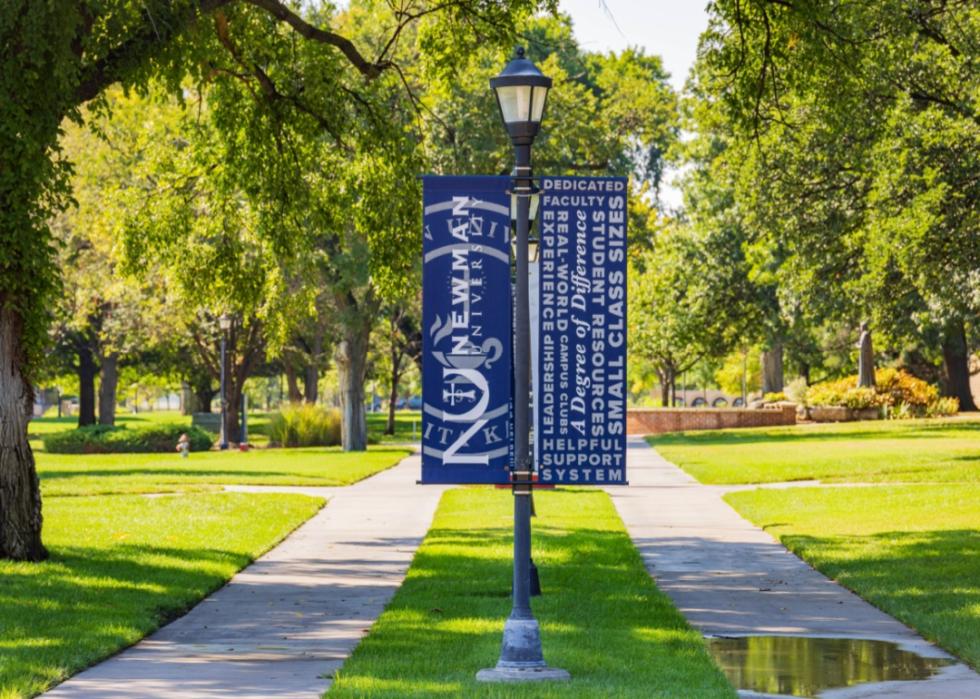 A blue Newman University sign on campus.