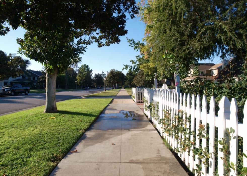 A white picket fence on a residential street.