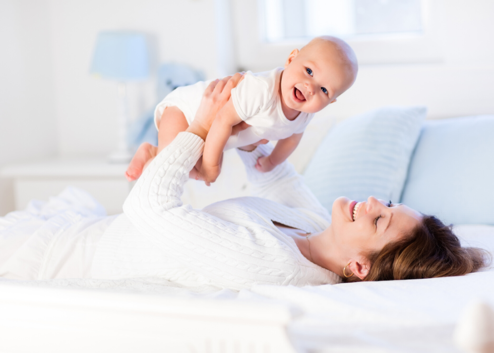 Mother and baby on a white bed.