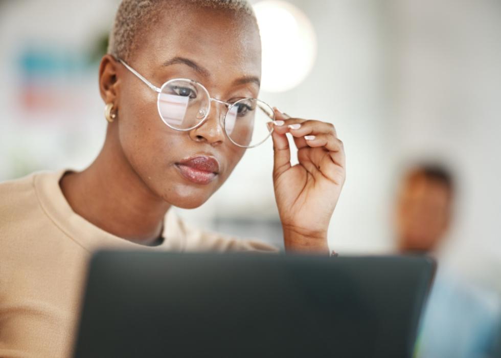 A woman looking at a laptop.