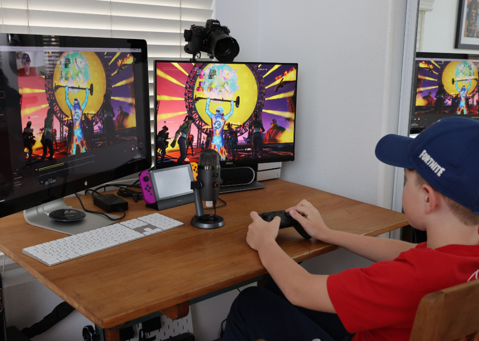 A kid playing games with two screens at home.
